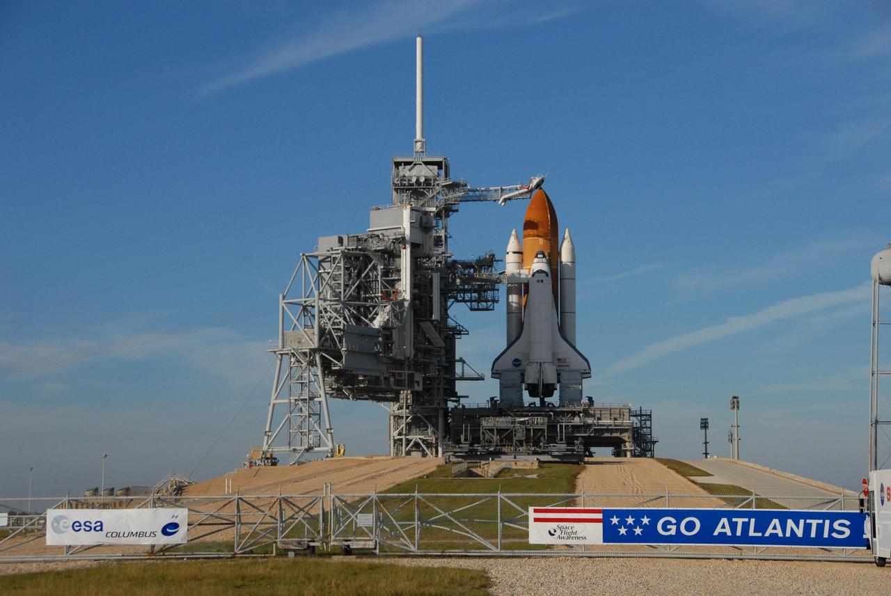 KENNEDY SPACE CENTER, FLA. -- Shadows spill across space shuttle Atlantis, still poised on the pad after its launch on mission STS-122 was postponed Thursday.  It sits atop the mobile launcher platform. Shuttle program managers decided at 9:56 a.m. to postpone the launch because of an issue with a fuel cut-off sensor system inside the external fuel tank. This is one of several systems that protect the shuttle's main engines by triggering their shut down if fuel runs unexpectedly low. During countdown activities this morning, two sensors failed a routine prelaunch check. There are four engine cut-off, or ECO, sensors inside the liquid hydrogen section of the tank, and Launch Commit Criteria require three of the four sensor systems to be functioning properly. The tank's liquid oxygen and liquid hydrogen was drained from the tank, and preparations will begin for a possible launch attempt Friday. NASA's launch rules have a preplanned procedure that states in the case of ECO sensor system failure, engineers need to drain the tank and verify all the sensors are working as they go dry. Atlantis carries the Columbus Laboratory, the European Space Agency's largest contribution to the construction of the space station.  When permanently attached to Node 2, the laboratory will carry out experiments in materials science, fluid physics and biosciences, as well as perform a number of technological applications, in a microgravity environment.  Photo credit: NASA/George Shelton