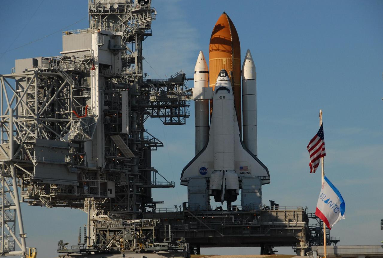 KENNEDY SPACE CENTER, FLA. -- In the late afternoon shadows, space shuttle Atlantis is still poised on the pad after its launch on mission STS-122 was postponed Thursday. It sits atop the mobile launcher platform. Shuttle program managers decided at 9:56 a.m. to postpone the launch because of an issue with a fuel cut-off sensor system inside the external fuel tank. This is one of several systems that protect the shuttle's main engines by triggering their shut down if fuel runs unexpectedly low. During countdown activities this morning, two sensors failed a routine prelaunch check. There are four engine cut-off, or ECO, sensors inside the liquid hydrogen section of the tank, and Launch Commit Criteria require three of the four sensor systems to be functioning properly. The tank's liquid oxygen and liquid hydrogen was drained from the tank, and preparations will begin for a possible launch attempt Friday. NASA's launch rules have a preplanned procedure that states in the case of ECO sensor system failure, engineers need to drain the tank and verify all the sensors are working as they go dry. Atlantis carries the Columbus Laboratory, the European Space Agency's largest contribution to the construction of the space station.  When permanently attached to Node 2, the laboratory will carry out experiments in materials science, fluid physics and biosciences, as well as perform a number of technological applications, in a microgravity environment.  Photo credit: NASA/George Shelton
