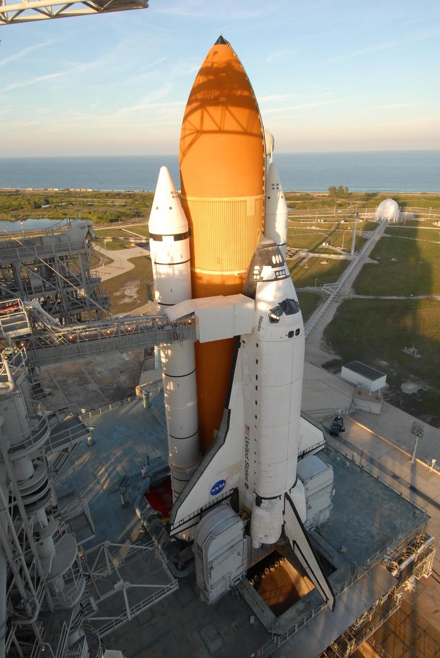 KENNEDY SPACE CENTER, FLA. -- Shadows spill across space shuttle Atlantis, still poised on the pad after its launch on mission STS-122 was postponed Thursday.  In the background is the Atlantic Ocean. Shuttle program managers decided at 9:56 a.m. to postpone the launch because of an issue with a fuel cut-off sensor system inside the external fuel tank. This is one of several systems that protect the shuttle's main engines by triggering their shut down if fuel runs unexpectedly low. During countdown activities this morning, two sensors failed a routine prelaunch check. There are four engine cut-off, or ECO, sensors inside the liquid hydrogen section of the tank, and Launch Commit Criteria require three of the four sensor systems to be functioning properly. The tank's liquid oxygen and liquid hydrogen was drained from the tank, and preparations will begin for a possible launch attempt Friday. NASA's launch rules have a preplanned procedure that states in the case of ECO sensor system failure, engineers need to drain the tank and verify all the sensors are working as they go dry. Atlantis carries the Columbus Laboratory, the European Space Agency's largest contribution to the construction of the space station.  When permanently attached to Node 2, the laboratory will carry out experiments in materials science, fluid physics and biosciences, as well as perform a number of technological applications, in a microgravity environment.  Photo credit: NASA/George Shelton