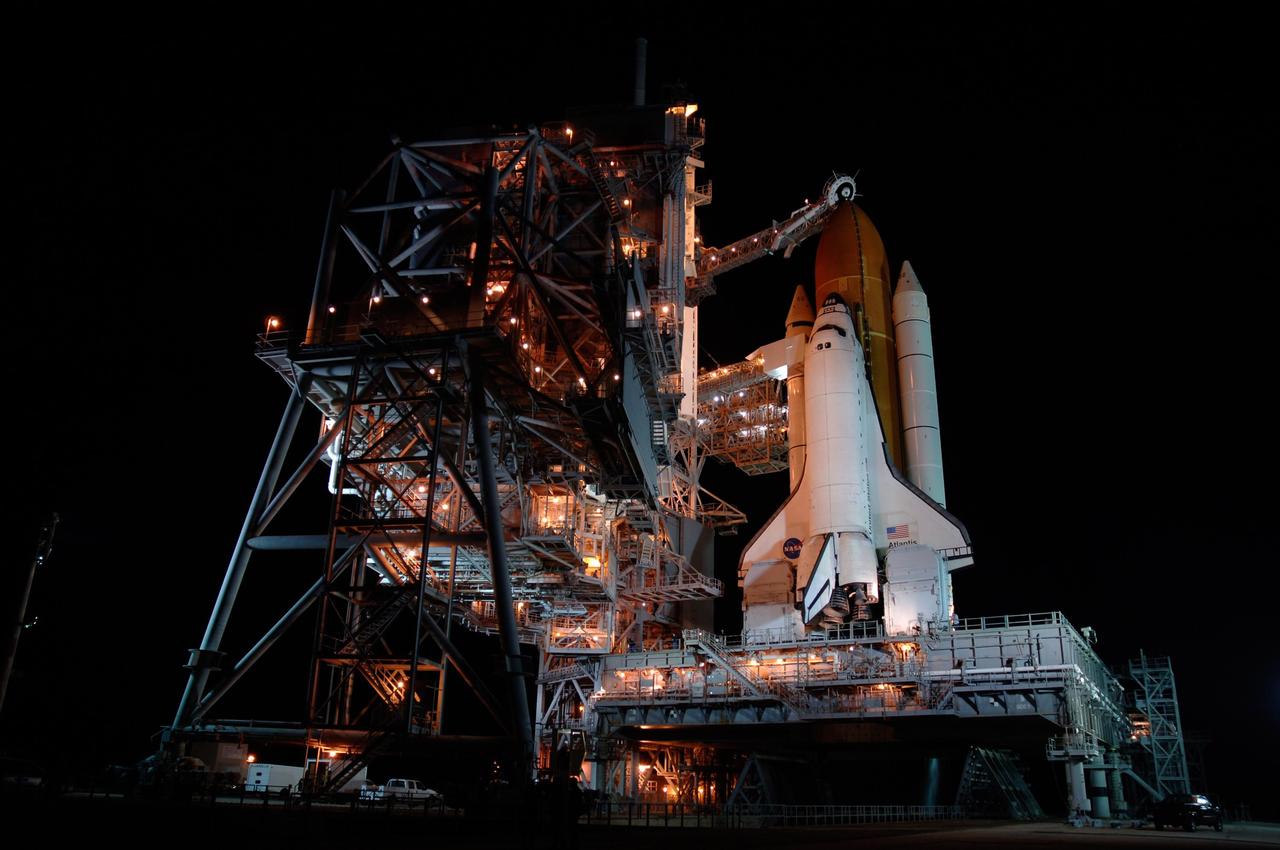 KENNEDY SPACE CENTER, FLA. -- Space shuttle Atlantis is revealed on Launch Pad 39A at NASA's Kennedy Space Center after the rotating service structure, or RSS, at left of the pad was rolled back. Rollback was complete at 9:49 p.m. EST. The RSS provides protected access to the orbiter for crew entry and servicing of payloads at the pad. Beneath the shuttle is the mobile launcher platform which supports the shuttle until liftoff. Rollback of the pad's RSS is one of the milestones in preparation for the launch of mission STS-122. Launch was originally set for Dec. 6 but was rescheduled to 3:21 p.m. Dec. 9. The delay was caused by problems with the external tank's engine cutoff sensor system that arose during tanking on Dec. 6. Atlantis will carry the Columbus Laboratory, the European Space Agency's largest contribution to the construction of the International Space Station. It will support scientific and technological research in a microgravity environment. Permanently attached to the Harmony node of the space station, the laboratory will carry out experiments in materials science, fluid physics and biosciences, as well as perform a number of technological applications. Photo credit: NASA/Amanda Diller