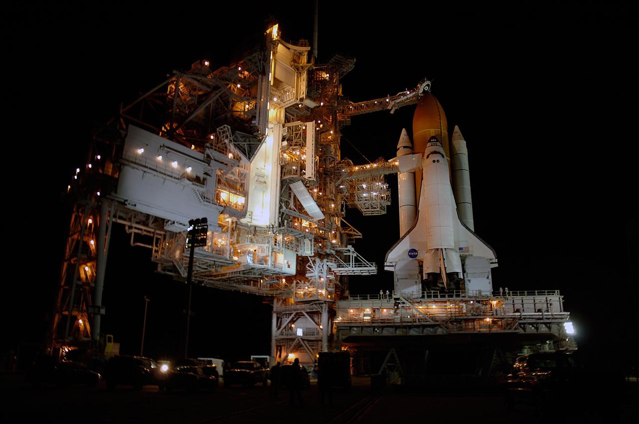KENNEDY SPACE CENTER, FLA. -- Space shuttle Atlantis is revealed on Launch Pad 39A at NASA's Kennedy Space Center after the rotating service structure, or RSS, at left of the pad was rolled back. Rollback was complete at 9:49 p.m. EST. The RSS provides protected access to the orbiter for crew entry and servicing of payloads at the pad. Beneath the shuttle is the mobile launcher platform which supports the shuttle until liftoff. Rollback of the pad's RSS is one of the milestones in preparation for the launch of mission STS-122. Launch was originally set for Dec. 6 but was rescheduled to 3:21 p.m. Dec. 9. The delay was caused by problems with the external tank's engine cutoff sensor system that arose during tanking on Dec. 6. Atlantis will carry the Columbus Laboratory, the European Space Agency's largest contribution to the construction of the International Space Station. It will support scientific and technological research in a microgravity environment. Permanently attached to the Harmony node of the space station, the laboratory will carry out experiments in materials science, fluid physics and biosciences, as well as perform a number of technological applications. Photo credit: NASA/Amanda Diller