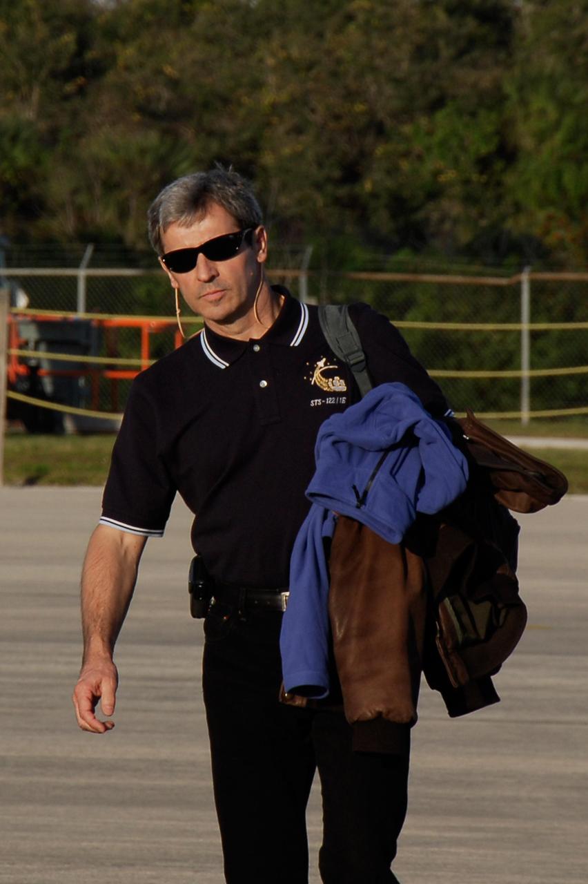 KENNEDY SPACE CENTER, FLA. -- On the Shuttle Landing Facility at NASA's Kennedy Space Center, STS-122 Mission Specialist Leopold Eyharts heads for the plane for the return trip to Houston. The crew is flying back to Houston after launch of space shuttle Atlantis was delayed when a failure occurred in a fuel sensor system while the vehicle's external fuel tank was being filled. Eyharts was scheduled to join the Expedition 16 crew aboard the International Space Station. One of the four engine cutoff, or ECO, sensors inside the liquid hydrogen section of the tank gave a false reading and NASA's current Launch Commit Criteria require that all four sensors function properly. The sensor system is one of several that protect the shuttle's main engines by triggering their shut down if fuel runs unexpectedly low. Space shuttle Atlantis' STS-122 mission now is targeted to launch no earlier than Jan. 2. The liftoff date depends on the resolution of the problem in the fuel sensor system. Photo credit: NASA/Kim Shiflett