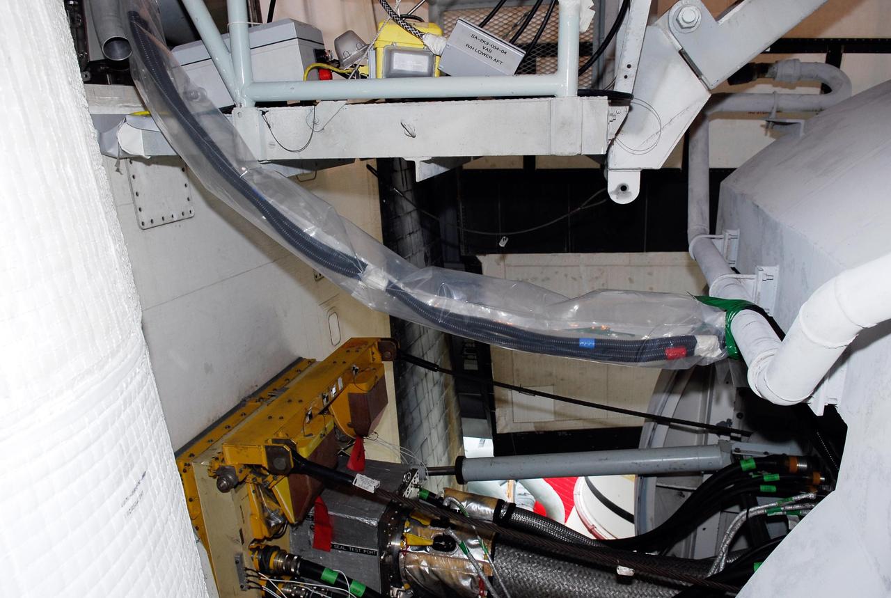 KENNEDY SPACE CENTER, FLA.  --  On Launch Pad 39A, cables lead from an electrical harness in space shuttle Atlantis' aft main engine compartment connected with the engine cut-off, or ECO, system into the tail mast. The test wiring leads from the tail mast to the interior of the mobile launcher platform where the Time Domain Reflectometry, or TDR, test equipment will be located to test the sensor system. The shuttle's planned launches on Dec. 6 and Dec. 9 were postponed because of false readings from the part of the ECO system that monitors the liquid hydrogen section of the tank. The liftoff date from NASA's Kennedy Space Center, Florida, is now targeted for Jan. 10, depending on the resolution of the problem in the fuel sensor system.  Photo credit: NASA/Kim Shiflett