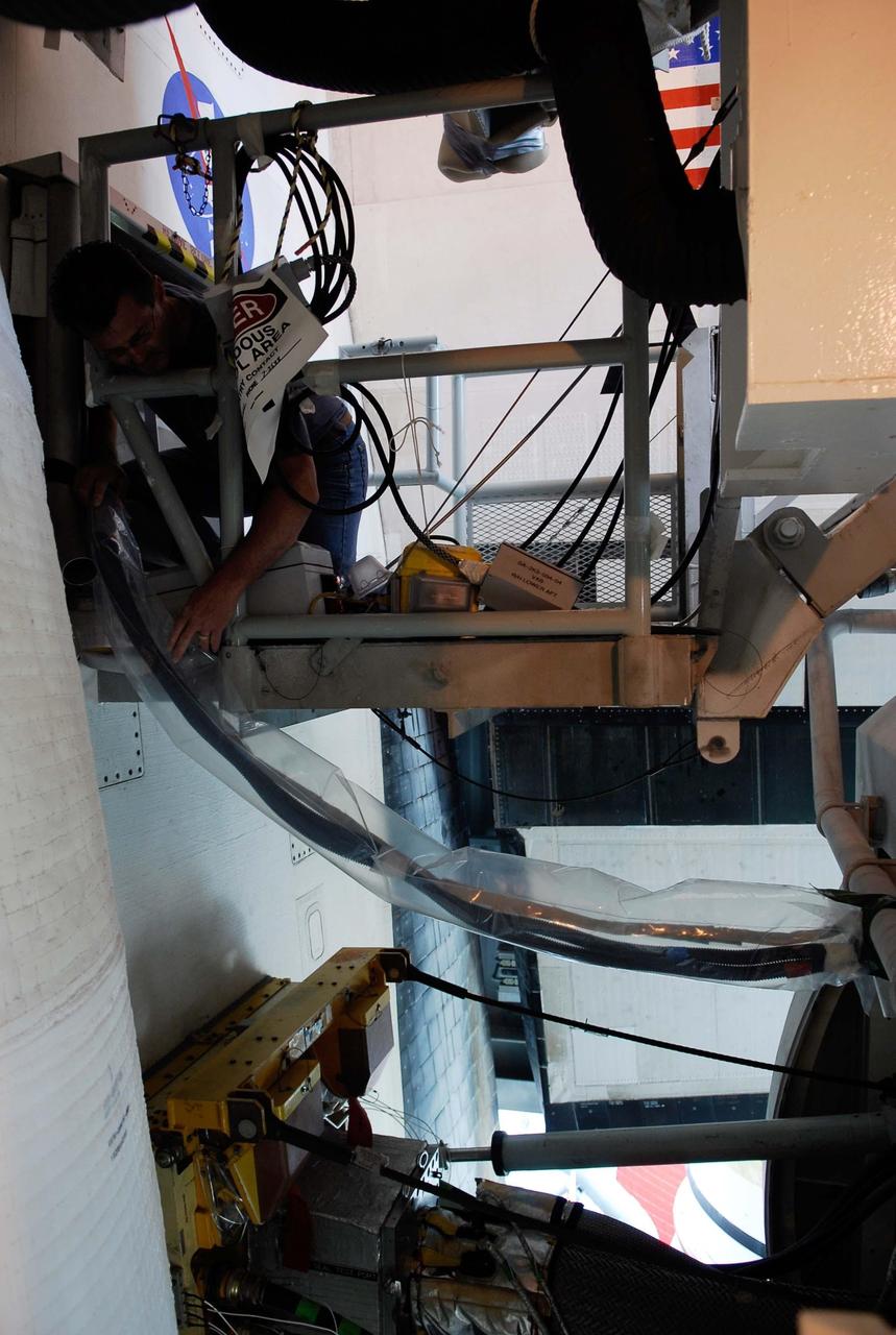KENNEDY SPACE CENTER, FLA.  --  On Launch Pad 39A, cables lead from an electrical harness in space shuttle Atlantis' aft main engine compartment connected with the engine cut-off, or ECO, system into the tail mast. The test wiring leads from the tail mast to the interior of the mobile launcher platform where the Time Domain Reflectometry, or TDR, test equipment will be located to test the sensor system.  The shuttle's planned launches on Dec. 6 and Dec. 9 were postponed because of false readings from the part of the ECO system that monitors the liquid hydrogen section of the tank. The liftoff date from NASA's Kennedy Space Center, Florida, is now targeted for Jan. 10, depending on the resolution of the problem in the fuel sensor system.  Photo credit: NASA/Kim Shiflett