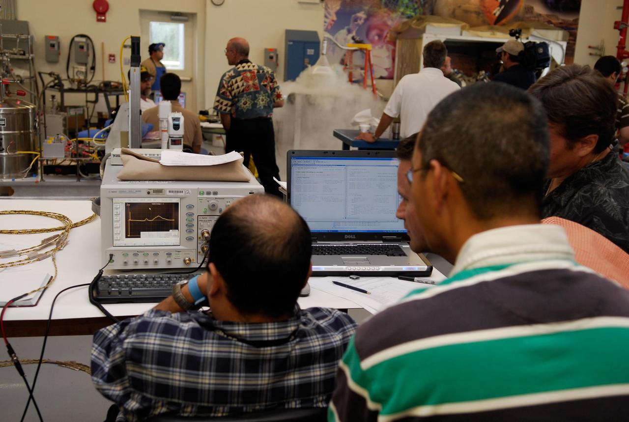 KENNEDY SPACE CENTER, FLA.  --  In the cryogenic test bed facility at NASA's Kennedy Space Center, technicians monitor readings during a test exposing Time Domain Reflectometry, or TDR, instrumentation to "wet" super-cold temperatures for identifying the signature of a cryogenic environment and calibrating the TDR equipment.  The equipment will be used at the launch pad to test a procedure identical to a tanking test on space shuttle Atlantis' external tank planned for Dec. 18.  The shuttle's planned launches on Dec. 6 and Dec. 9 were postponed because of false readings from the part of the engine cut-off, or ECO, sensor system that monitors the liquid hydrogen section of the tank. The liftoff date from NASA's Kennedy Space Center, Florida, is now targeted for Jan. 10, depending on the resolution of the problem in the fuel sensor system.  Photo credit: NASA/Kim Shiflett
