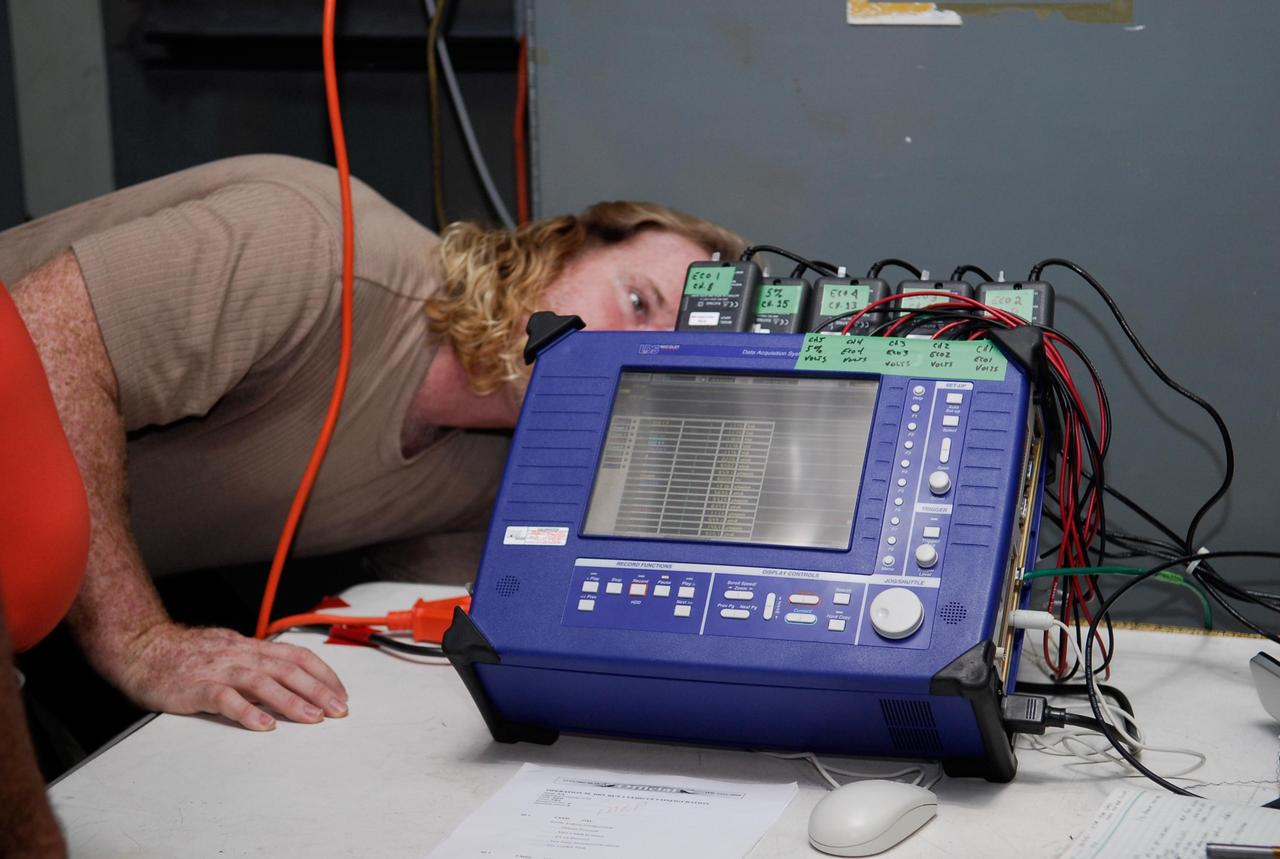 KENNEDY SPACE CENTER, FLA.  --  On Launch Pad 39A at NASA's Kennedy Space Center, a technician checks the blue monitor that will be used to validate the circuit on test wiring during the tanking test on space shuttle Atlantis' external tank.  The test wiring has been spliced into an electrical harness in the aft main engine compartment connected with the engine cut-off, or ECO, sensor system. The attached wiring leads to the interior of the mobile launcher platform where the time domain reflectometry, or TDR,  test equipment is located.  Photo credit: NASA/Kim Shiflett