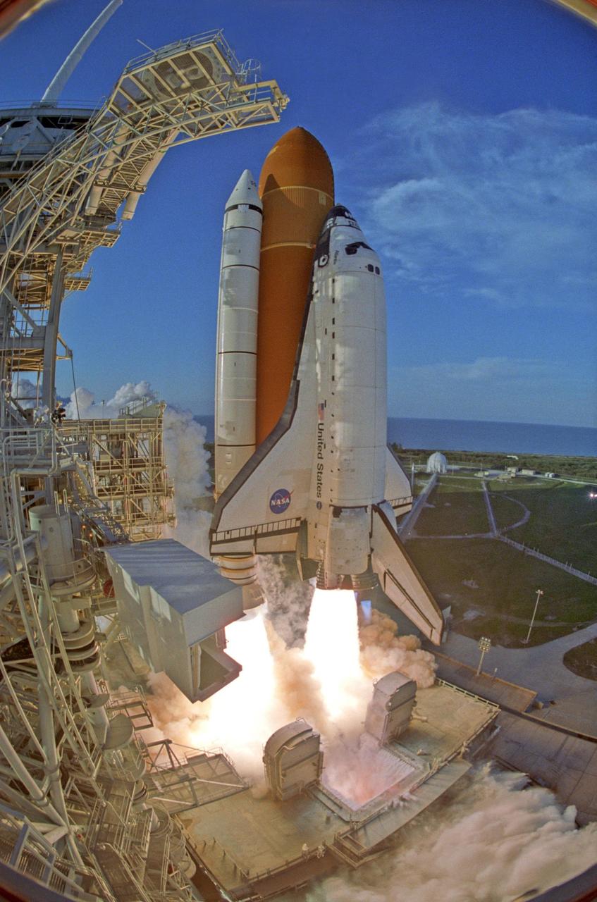 KENNEDY SPACE CENTER, FLA. --   A fish-eye view captures Space Shuttle Atlantis at liftoff from Launch Pad 39A as twin columns of fire propel it toward the sky.  Smoke is pouring from the flame trench below (lower right), between the tail service masts and beyond the service structure.  On the left of the orbiter's wing is the White Room, which provides access into the orbiter for the astronauts and swings away before final countdown. Liftoff of Atlantis on mission STS-117 to the International Space Station was on-time at 7:38:04 p.m. EDT. The shuttle is delivering a new segment to the starboard side of the International Space Station's backbone, known as the truss. Three spacewalks are planned to install the S3/S4 truss segment, deploy a set of solar arrays and prepare them for operation. STS-117 is the 118th space shuttle flight, the 21st flight to the station, the 28th flight for Atlantis and the first of four flights planned for 2007.  Photo Credit: NASA/Rick Wetherington & Tony Gray