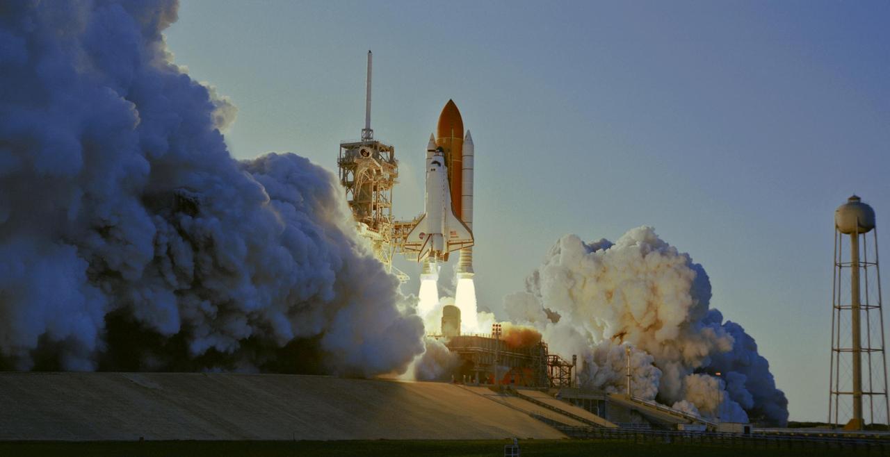 KENNEDY SPACE CENTER, FLA. --  Smoke and steam billow across Launch Pad 39A as Space Shuttle Atlantis, trailing columns of fire from the solid rocket boosters, hurtles into the sky on mission STS-117 to the International Space Station. At left is the fixed service structure with the 80-foot-tall lightning mast on top.  At right is the 290-foot-high water tower that supplies the water for sound suppression.  Liftoff was on-time at 7:38:04 p.m. EDT. The shuttle is delivering a new segment to the starboard side of the International Space Station's backbone, known as the truss. Three spacewalks are planned to install the S3/S4 truss segment, deploy a set of solar arrays and prepare them for operation. STS-117 is the 118th space shuttle flight, the 21st flight to the station, the 28th flight for Atlantis and the first of four flights planned for 2007.  Photo credit: NASA/Tony Gray & Don Kight