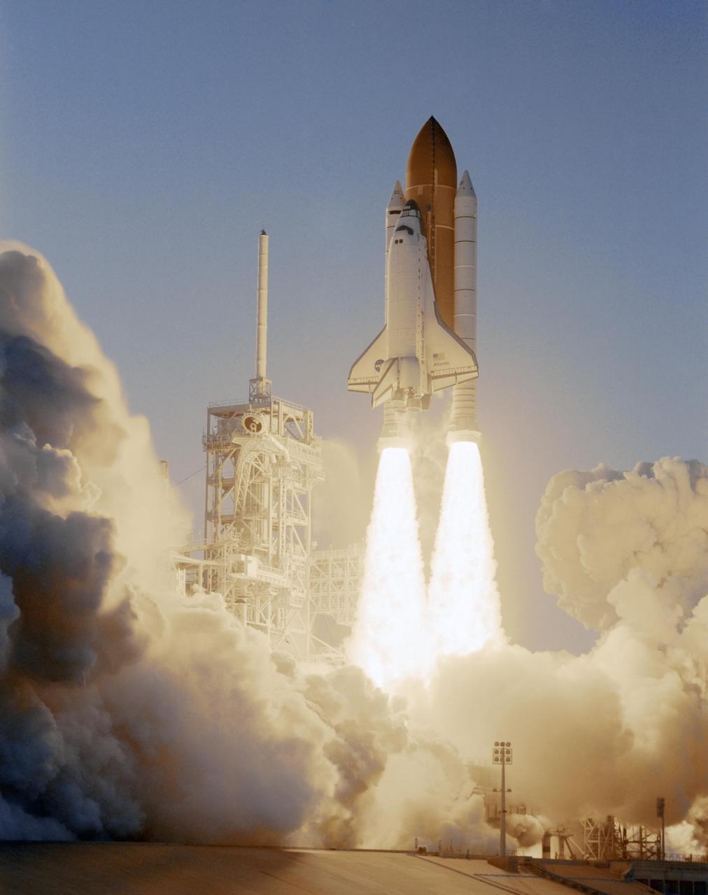 KENNEDY SPACE CENTER, FLA. --  Smoke and steam billow across Launch Pad 39A as Space Shuttle Atlantis, trailing columns of fire from the solid rocket boosters, hurtles into the sky on mission STS-117 to the International Space Station. At left is the fixed service structure with the 80-foot-tall lightning mast on top.  Liftoff was on-time at 7:38:04 p.m. EDT. The shuttle is delivering a new segment to the starboard side of the International Space Station's backbone, known as the truss. Three spacewalks are planned to install the S3/S4 truss segment, deploy a set of solar arrays and prepare them for operation. STS-117 is the 118th space shuttle flight, the 21st flight to the station, the 28th flight for Atlantis and the first of four flights planned for 2007.  Photo credit: NASA/Tony Gray & Don Kight