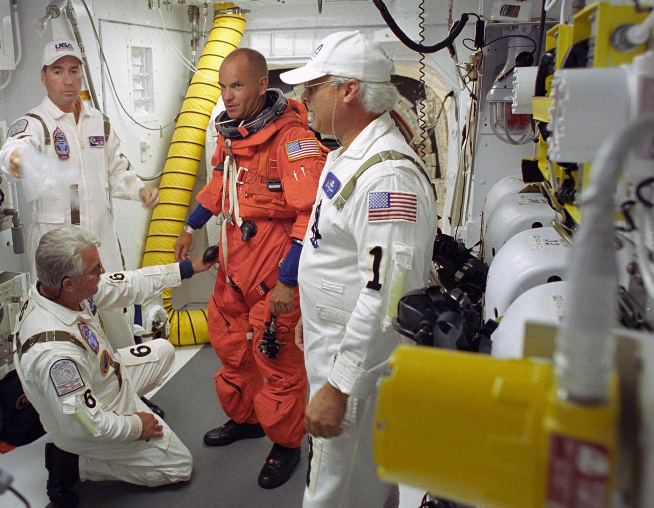 KENNEDY SPACE CENTER, FLA. --  STS-117 Commander Frederick Sturckow is helped by the closeout crew in the White Room on Launch Pad 39A to secure his launch suit before climbing into Space Shuttle Atlantis.  The mission to the International Space Station is scheduled to launch at 7:38 p.m. EDT. Members of the Closeout Crew help the astronauts don a parachute pack, strap them into the space shuttle's crew module and take care of any other last-minute needs that arise. The White Room is at the end of the orbiter access arm that extends from the fixed service structure and provides entry into the orbiter. The shuttle is delivering a new segment to the starboard side of the space station's backbone, known as the truss. Three spacewalks are planned to install the S3/S4 truss segment, deploy a set of solar arrays and prepare them for operation. STS-117 is the 118th space shuttle flight, the 21st flight to the station, the 28th flight for Atlantis and the first of four flights planned for 2007.  Photo credit: NASA/Tony Gray & Don Kight