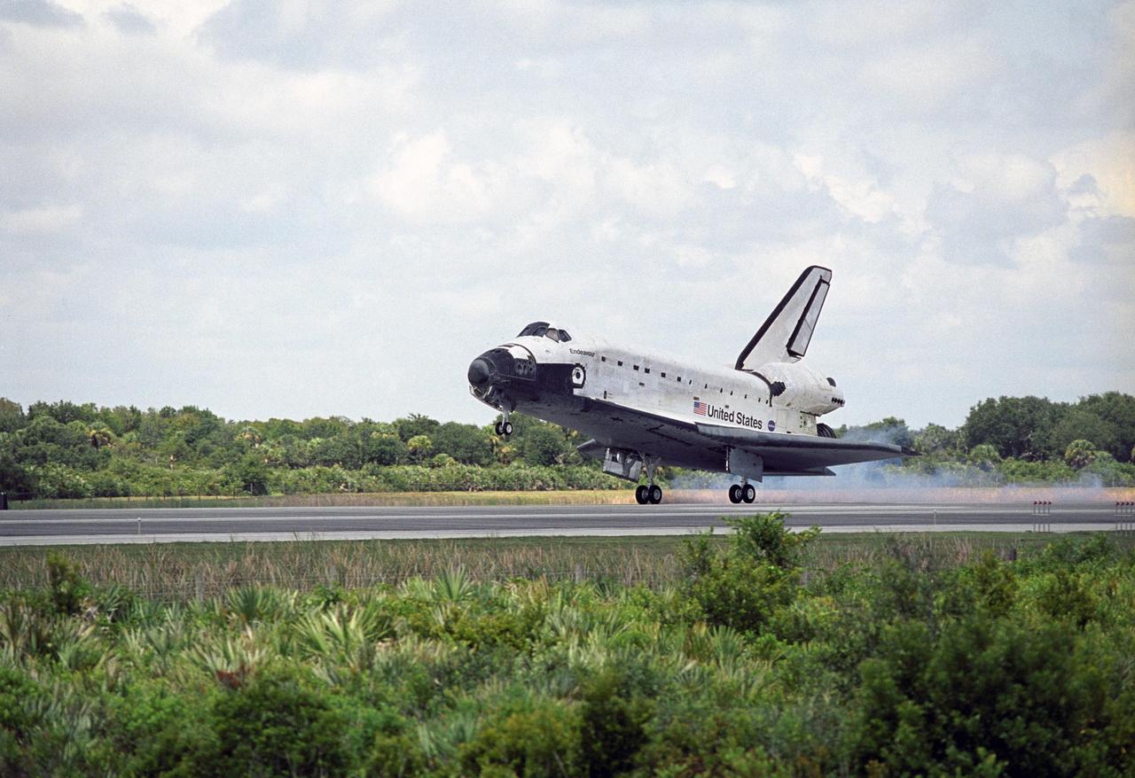 KENNEDY SPACE CENTER, FLA. -- Clouds belie the bright blue sky as Endeavour's wheels kick up dust touching down on runway 15 at NASA's Kennedy Space Center, completing a 13-day mission to the International Space Station. The STS-118 mission began Aug. 8 and installed a new gyroscope, an external spare parts platform and another truss segment to the expanding station.  Endeavour's main gear touched down at 12:32:16  p.m. EDT.  Nose gear touchdown was at 12:32:29 p.m. and wheel stop was at 12:33:20 p.m.  Endeavour traveled nearly 5.3 million miles, landing on orbit 201.  STS-118 was the 119th space shuttle flight, the 22nd flight to the station, the 20th flight for Endeavour and the second of four missions planned for 2007. This was the 65th landing of an orbiter at Kennedy.  Photo credit: NASA/Tony Gray