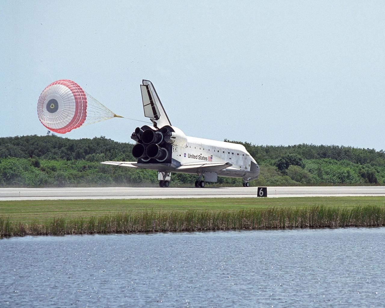 KENNEDY SPACE CENTER, FLA. --With drag chute sailing behind, Endeavour rolls down runway 15 at NASA's Kennedy Space Center, completing a 13-day mission to the International Space Station. The mission began Aug. 8 and installed a new gyroscope, an external spare parts platform and another truss segment to the expanding station. Endeavour's main gear touched down at 12:32:16 p.m. EDT. Nose gear touchdown was at 12:32:29 p.m. and wheel stop was at 12:33:20 p.m. Endeavour traveled nearly 5.3 million miles, landing on orbit 201. STS-118 was the 119th space shuttle flight, the 22nd flight to the station, the 20th flight for Endeavour and the second of four missions planned for 2007. This was the 65th landing of an orbiter at Kennedy. Photo credit: NASA/Regina Mitchell-Ryall, Robert Murray