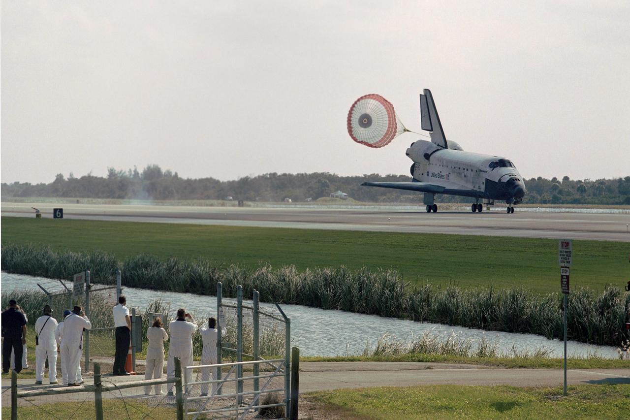 KENNEDY SPACE CENTER, FLA. --  Photographers at lower left capture the release of the drag chute behind space shuttle Discovery as it lands on Runway 33 of the Shuttle Landing Facility at NASA's Kennedy Space Center to complete the 15-day mission STS-120. Main gear touchdown was 1:01:16 p.m.  Wheel stop was at 1:02:07 p.m.  Mission elapsed time was 15 days, 2 hours, 24 minutes and 2 seconds.  During the mission, the STS-120 crew continued the construction of the station with the installation of the Harmony Node 2 module and the relocation of the P6 truss.  Photo credit: NASA/Sandra Joseph, Tim Powers