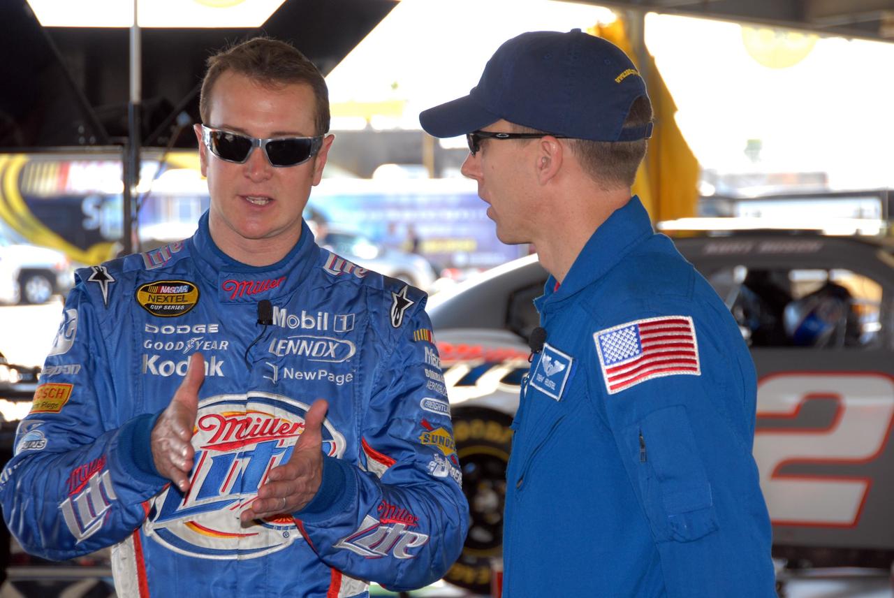 KENNEDY SPACE CENTER, FLA. -- NASCAR driver Kurt Busch (left) talks to astronaut Andrew Feustel about driving. Feustel is participating in NASCAR's Preseason Thunder Fan Fest at Daytona International Speedway. Feustel's appearance celebrates NASA's 50th anniversary and the speedway's 50th running of the Daytona 500 in February. Besides meeting with fans and media, Feustel will ride around the track, taking "hot laps," in an official track vehicle. The NASA/NASCAR association spans decades. Technology developed for the space program has helped NASCAR drivers increase their performance and stay safe over the years. They wear cooling suits similar to what astronauts wear during a spacewalk. Foam that NASA developed for aircraft seats protects racecar drivers' necks in crashes. In addition to participating in the fan festival, NASA will fly three Daytona 500 flags aboard an upcoming space shuttle flight. Speedway officials plan to wave one of the flags to begin the 2008 installment of the Daytona 500, while another will be presented to the winning driver. NASA will keep the third. Feustel will fly on the space shuttle mission STS-125 to the Hubble Space Telescope. The mission will extend and improve the observatory's capabilities through 2013. Launch is targeted for August 2008. Photo credit: NASA/George Shelton
