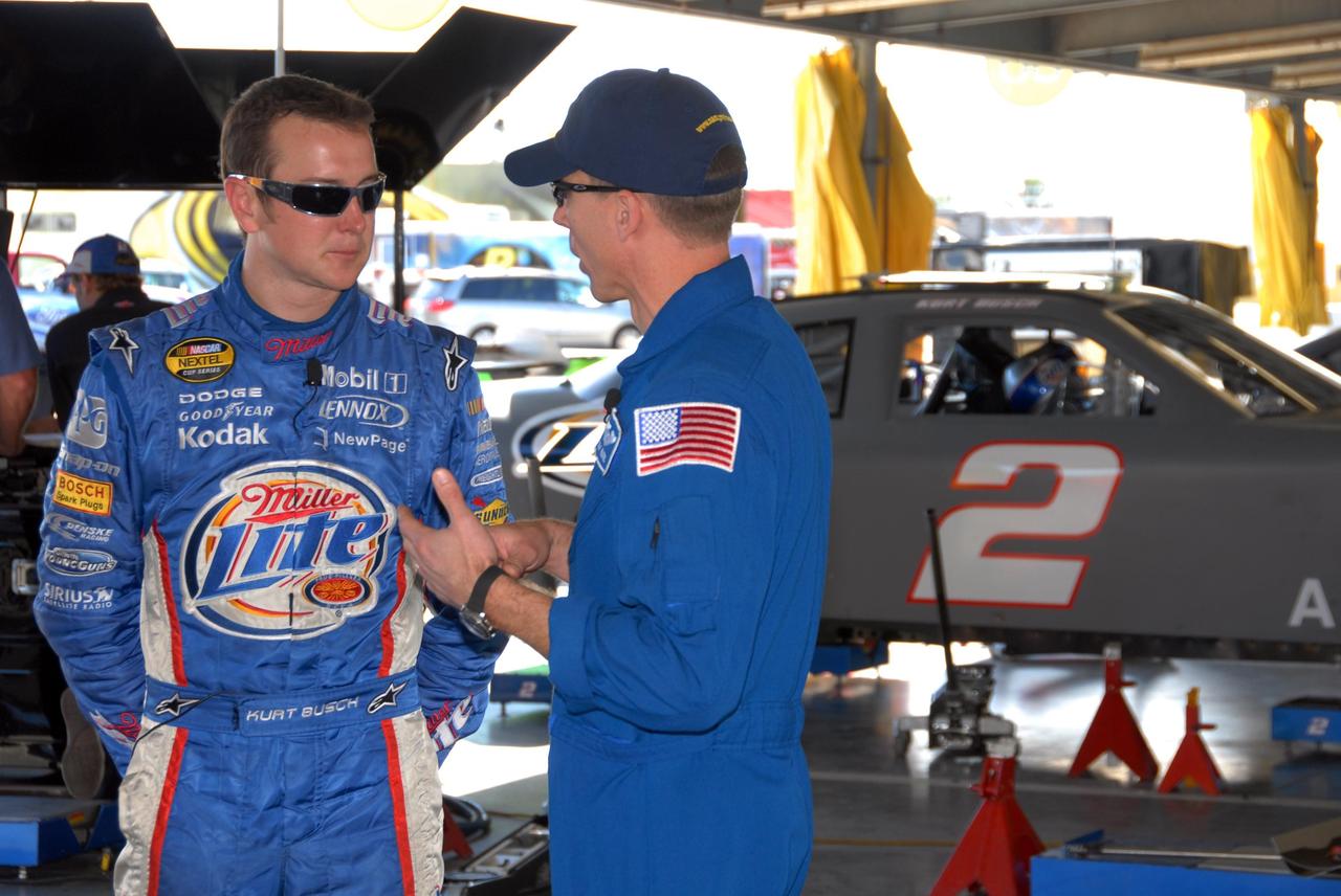 KENNEDY SPACE CENTER, FLA. -- Astronaut Andrew Feustel (right) talks to NASCAR driver Kurt Busch about his pending "hot laps" in an official track vehicle around the Daytona International Speedway. Feustel is participating in NASCAR's Preseason Thunder Fan Fest at. Feustel's appearance celebrates NASA's 50th anniversary and the speedway's 50th running of the Daytona 500 in February. Besides the driving experience, Feuster will meet with fans and the media. The NASA/NASCAR association spans decades. Technology developed for the space program has helped NASCAR drivers increase their performance and stay safe over the years. They wear cooling suits similar to what astronauts wear during a spacewalk. Foam that NASA developed for aircraft seats protects racecar drivers' necks in crashes. In addition to participating in the fan festival, NASA will fly three Daytona 500 flags aboard an upcoming space shuttle flight. Speedway officials plan to wave one of the flags to begin the 2008 installment of the Daytona 500, while another will be presented to the winning driver. NASA will keep the third. Feustel will fly on the space shuttle mission STS-125 to the Hubble Space Telescope. The mission will extend and improve the observatory's capabilities through 2013. Launch is targeted for August 2008. Photo credit: NASA/George Shelton