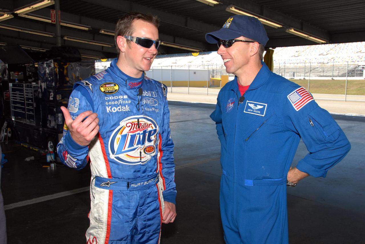 KENNEDY SPACE CENTER, FLA. -- NASCAR driver Kurt Busch (left) talks to astronaut Andrew Feustel about driving. Feustel is participating in NASCAR's Preseason Thunder Fan Fest at Daytona International Speedway. Feustel's appearance celebrates NASA's 50th anniversary and the speedway's 50th running of the Daytona 500 in February. Besides meeting with fans and media, Feustel will ride around the track, taking "hot laps," in an official track vehicle. The NASA/NASCAR association spans decades. Technology developed for the space program has helped NASCAR drivers increase their performance and stay safe over the years. They wear cooling suits similar to what astronauts wear during a spacewalk. Foam that NASA developed for aircraft seats protects racecar drivers' necks in crashes. In addition to participating in the fan festival, NASA will fly three Daytona 500 flags aboard an upcoming space shuttle flight. Speedway officials plan to wave one of the flags to begin the 2008 installment of the Daytona 500, while another will be presented to the winning driver. NASA will keep the third. Feustel will fly on the space shuttle mission STS-125 to the Hubble Space Telescope. The mission will extend and improve the observatory's capabilities through 2013. Launch is targeted for August 2008. Photo credit: NASA/George Shelton