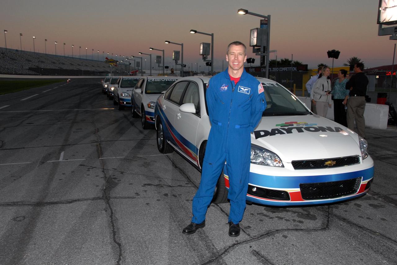 KENNEDY SPACE CENTER, FLA. -- Astronaut Andrew Feustel poses with track vehicles during NASCAR's Preseason Thunder Fan Fest at the Daytona International Speedway. Feustel's appearance celebrates NASA's 50th anniversary and the speedway's 50th running of the Daytona 500 in February. The NASA/NASCAR association spans decades. Technology developed for the space program has helped NASCAR drivers increase their performance and stay safe over the years. They wear cooling suits similar to what astronauts wear during a spacewalk. Foam that NASA developed for aircraft seats protects racecar drivers' necks in crashes. In addition to participating in the fan festival, NASA will fly three Daytona 500 flags aboard an upcoming space shuttle flight. Speedway officials plan to wave one of the flags to begin the 2008 installment of the Daytona 500, while another will be presented to the winning driver. NASA will keep the third. Feustel will fly on the space shuttle mission STS-125 to the Hubble Space Telescope. The mission will extend and improve the observatory's capabilities through 2013. Launch is targeted for August 2008. Photo credit: NASA/George Shelton
