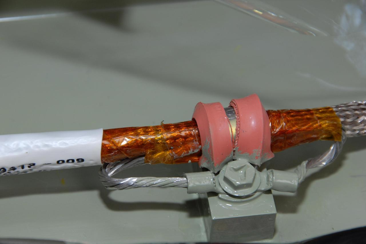 KENNEDY SPACE CENTER, FLA. --  This closeup shows the final splicing completed on the wiring between space shuttle Atlantis' external tank and the engine cutoff, or ECO, sensor system before the replacement feed-through connector in the ECO sensor system is installed. Cryogenic shielding is installed around the wiring. The feed-through connector passes the wires from the inside of the tank to the outside.  Results of a tanking test on Dec. 18 pointed to an open circuit in the feed-through connector wiring, which is located at the base of the tank. The pins in the replacement connector have been precisely soldered to create a connection that allows sensors inside the tank to send signals to the computers onboard Atlantis. The work is being done on Launch Pad 39A.   Space shuttle Atlantis is now targeted for launch on Feb. 7.  Photo credit: NASA/George Shelton