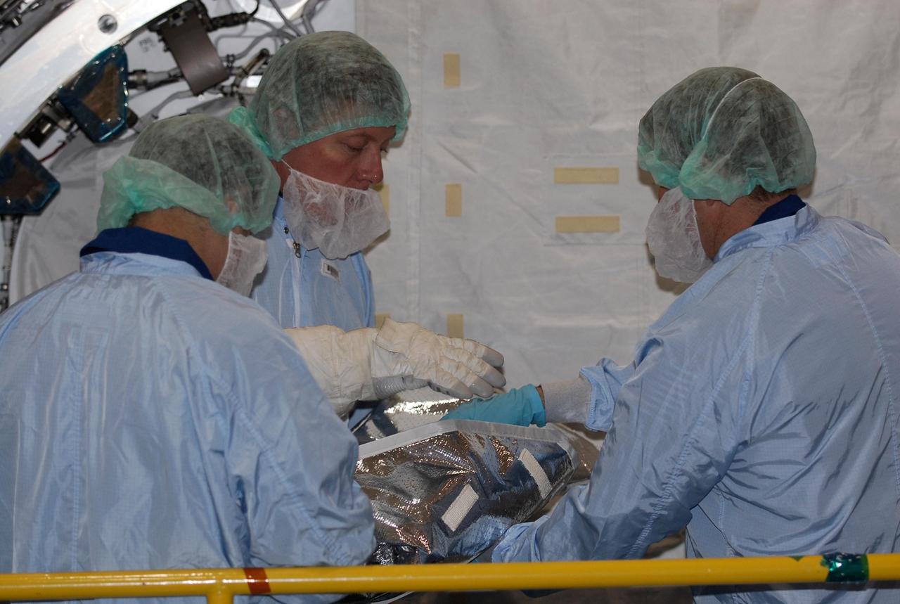 KENNEDY SPACE CENTER, FLA. -- In the Space Station Processing Facility at NASA's Kennedy Space Center, STS-124 Mission Specialist Michael Fossum (facing camera) gets hands-on experience with equipment that is part of the Kibo pressurized module. He and other crew members are at Kennedy for a crew equipment interface test that includes familiarization with tools and equipment that will be used on the mission, targeted for launch no earlier than April 24. The STS-124 mission is the second of three flights that will launch components to complete the Japanese pressurized module, the Kibo laboratory. The mission will include two spacewalks to install the new lab and its remote manipulator system. The lab's logistics module, which will have been installed in a temporary location during STS-123, will be attached to the new lab. Photo credit: NASA/Kim Shiflett