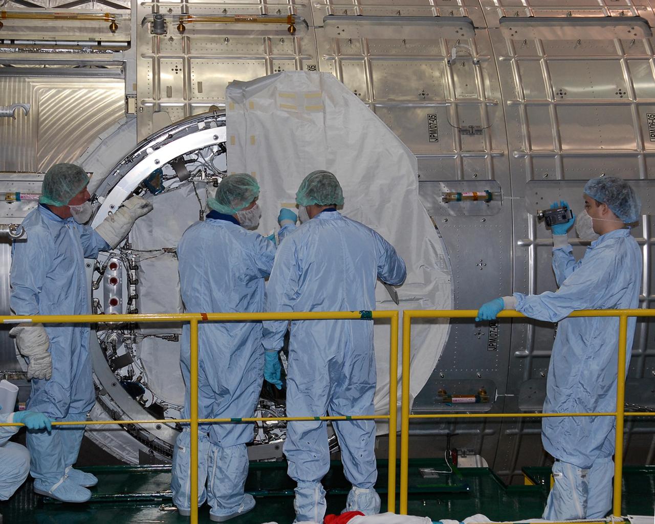 KENNEDY SPACE CENTER, FLA. -- In the Space Station Processing Facility at NASA's Kennedy Space Center, members of the STS-124 crew look over the scientific airlock in the Kibo pressurized module. The module is part of the payload for the mission, targeted for launch no earlier than April 24. The crew comprises seven: Commander Mark Kelly, Pilot Kenneth Ham, and Mission Specialists Karen Nyberg, Ronald Garan, Michael Fossum and Akihiko Hoshide. The crew is at Kennedy for a crew equipment interface test that includes familiarization with tools and equipment that will be used on the mission. The STS-124 mission is the second of three flights that will launch components to complete the Japanese pressurized module, the Kibo laboratory. The mission will include two spacewalks to install the new lab and its remote manipulator system. The lab's logistics module, which will have been installed in a temporary location during STS-123, will be attached to the new lab. Photo credit: NASA/Kim Shiflett