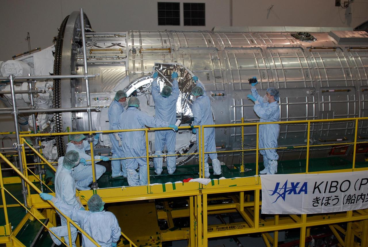 KENNEDY SPACE CENTER, FLA. -- In the Space Station Processing Facility at NASA's Kennedy Space Center, members of the STS-124 crew look over the scientific airlock in the Kibo pressurized module. The module is part of the payload for the mission, targeted for launch no earlier than April 24. The crew comprises seven: Commander Mark Kelly, Pilot Kenneth Ham, and Mission Specialists Karen Nyberg, Ronald Garan, Michael Fossum and Akihiko Hoshide. The crew is at Kennedy for a crew equipment interface test that includes familiarization with tools and equipment that will be used on the mission. The STS-124 mission is the second of three flights that will launch components to complete the Japanese pressurized module, the Kibo laboratory. The mission will include two spacewalks to install the new lab and its remote manipulator system. The lab's logistics module, which will have been installed in a temporary location during STS-123, will be attached to the new lab. Photo credit: NASA/Kim Shiflett