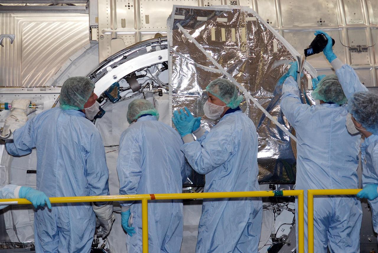 KENNEDY SPACE CENTER, FLA. -- In the Space Station Processing Facility at NASA's Kennedy Space Center, members of the STS-124 crew look over the scientific airlock in the Kibo pressurized module. The module is part of the payload for the mission, targeted for launch no earlier than April 24. The crew comprises seven: Commander Mark Kelly, Pilot Kenneth Ham, and Mission Specialists Karen Nyberg, Ronald Garan, Michael Fossum and Akihiko Hoshide. The crew is at Kennedy for a crew equipment interface test that includes familiarization with tools and equipment that will be used on the mission. The STS-124 mission is the second of three flights that will launch components to complete the Japanese pressurized module, the Kibo laboratory. The mission will include two spacewalks to install the new lab and its remote manipulator system. The lab's logistics module, which will have been installed in a temporary location during STS-123, will be attached to the new lab. Photo credit: NASA/Kim Shiflett