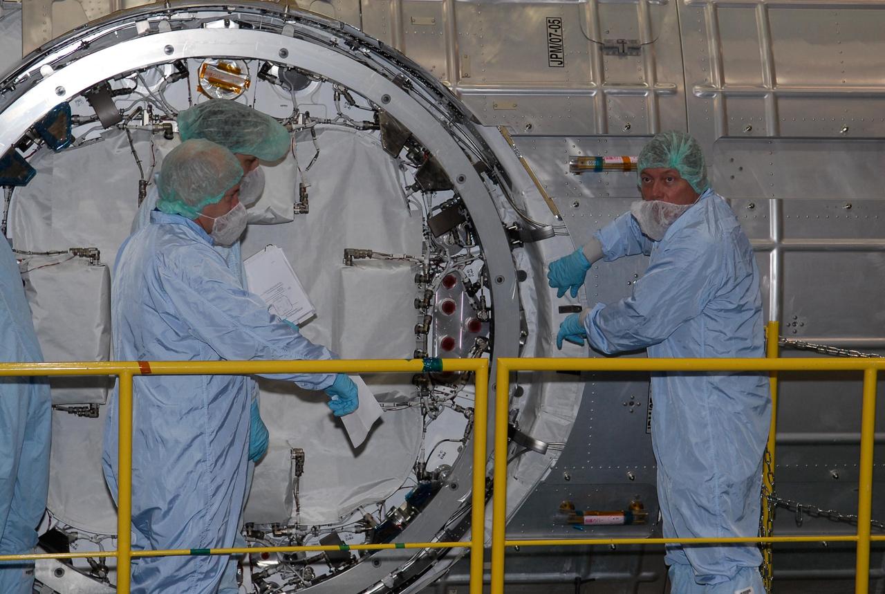 KENNEDY SPACE CENTER, FLA. -- In the Space Station Processing Facility at NASA's Kennedy Space Center, STS-124 Mission Specialist Michael Fossum (right) gets hands-on experience with the scientific airlock in the Kibo pressurized module. The module is part of the payload for the mission, targeted for launch no earlier than April 24. He and other crew members are at Kennedy for a crew equipment interface test that includes familiarization with tools and equipment that will be used on the mission. The STS-124 mission is the second of three flights that will launch components to complete the Japanese pressurized module, the Kibo laboratory. The mission will include two spacewalks to install the new lab and its remote manipulator system. The lab's logistics module, which will have been installed in a temporary location during STS-123, will be attached to the new lab. Photo credit: NASA/Kim Shiflett