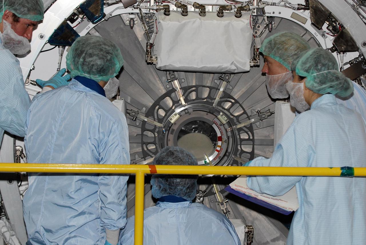 KENNEDY SPACE CENTER, FLA. -- In the Space Station Processing Facility at NASA's Kennedy Space Center, members of the STS-124 crew get a close look at the scientific airlock on Kibo pressurized module. The module is part of the payload for the mission, targeted for launch no earlier than April 24. Crew members are at Kennedy for a crew equipment interface test that includes familiarization with tools and equipment that will be used on the mission. The STS-124 mission is the second of three flights that will launch components to complete the Japanese pressurized module, the Kibo laboratory. The mission will include two spacewalks to install the new lab and its remote manipulator system. The lab's logistics module, which will have been installed in a temporary location during STS-123, will be attached to the new lab. Photo credit: NASA/Kim Shiflett