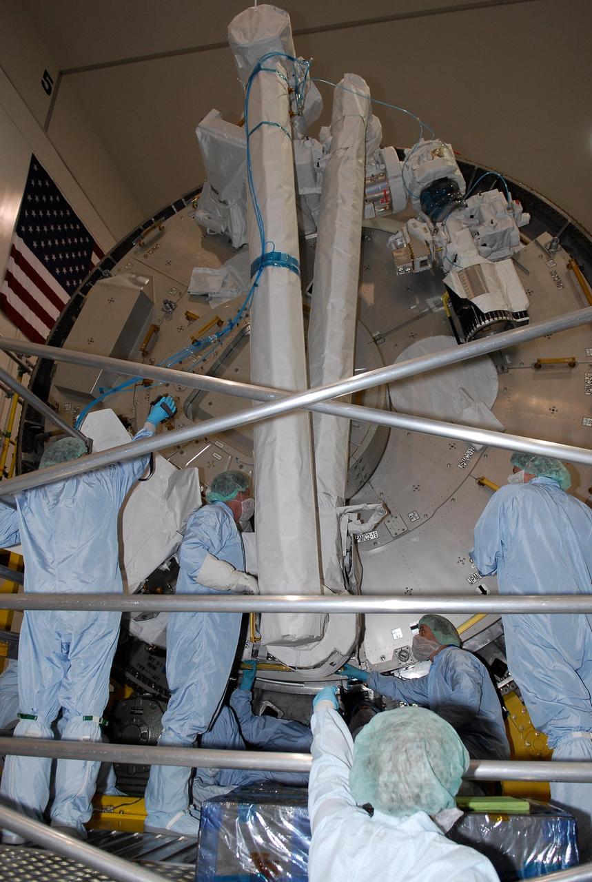 KENNEDY SPACE CENTER, FLA. -- In the Space Station Processing Facility at NASA's Kennedy Space Center, members of the STS-124 crew get a close look at the Remote Manipulator System, or RMS, two robotic arms that support operations on the outside of the Japanese Experiment Module, called Kibo.  They will be used to exchange experiment payloads or hardware located on the Exposed Facility and Experiment Logistics Module - Exposed Section and from inside the pressurized module through a scientific airlock, support maintenance tasks of Kibo and handle orbital replacement units. Crew members are at Kennedy for a crew equipment interface test that includes familiarization with tools and equipment that will be used on the mission.  The STS-124 mission is the second of three flights that will launch components to complete the Japanese pressurized module, the Kibo laboratory. The mission will include two spacewalks to install the new lab and its remote manipulator system. The lab's logistics module, which will have been installed in a temporary location during STS-123, will be attached to the new lab.  Photo credit: NASA/Kim Shiflett