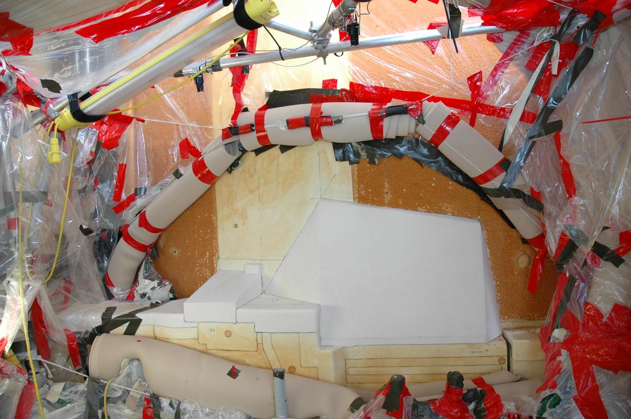 KENNEDY SPACE CENTER, FLA. --  The white foam insulation freshly reapplied to space shuttle Atlantis's external tank completes the work to remove and replace the feed-through connector on the engine cut-off, or ECO, sensor connector.  The repair work was done on Atlantis while the shuttle has been on Launch Pad 39A at NASA's Kennedy Space Center.   The foam was removed to enable engineers to remove and replace the ECO sensor connector on the tank.  The feed-through connector passes the wires from the inside of the tank to the outside.  Results of a tanking test on Dec. 18 pointed to an open circuit in the feed-through connector wiring, which is located at the base of the tank. The pins in the replacement connector were precisely soldered to create a connection that allows sensors inside the tank to send signals to the computers onboard Atlantis.  The repair work was done on Atlantis while the shuttle has been on Launch Pad 39A at NASA's Kennedy Space Center.  The launch date for the shuttle's STS-122 mission has now been targeted for Feb. 7.   Photo credit: NASA/Cory Husten