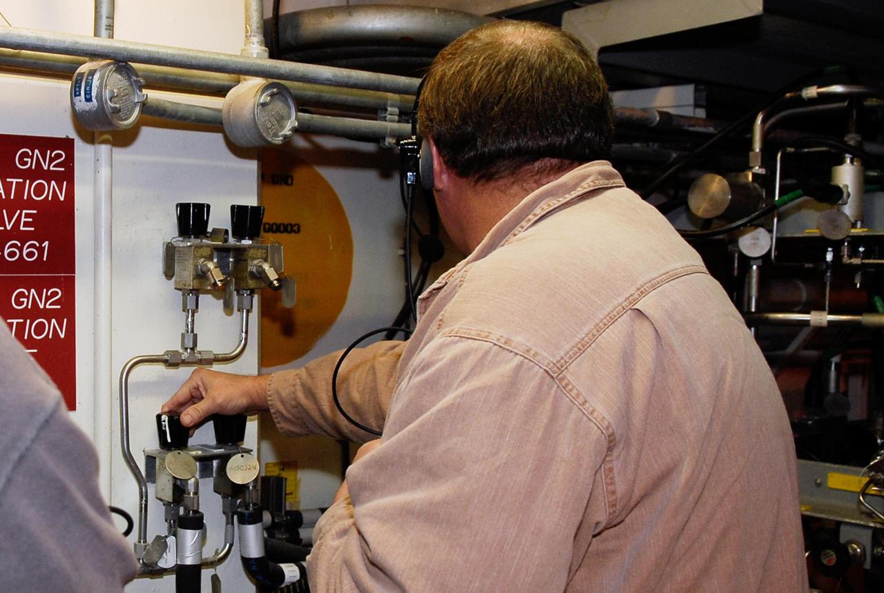 KENNEDY SPACE CENTER, FLA. -- In the hypergolic maintenance facility at NASA's Kennedy Space Center, a technician adjusts equipment during testing of the Ares I-X Roll Control System, or RoCS. The RoCS Servicing Simulation Test is to gather data that will be used to help certify the ground support equipment design and validate the servicing requirements and processes. The RoCS is part of the Interstage structure, the lowest axial segment of the Upper Stage Simulator. In an effort to reduce costs and meet the schedule, most of the ground support equipment that will be used for the RoCS servicing is of space shuttle heritage. This high-fidelity servicing simulation will provide confidence that servicing requirements can be met with the heritage system. At the same time, the test will gather process data that will be used to modify or refine the equipment and processes to be used for the actual flight element. Photo credit: NASA/Kim Shiflett