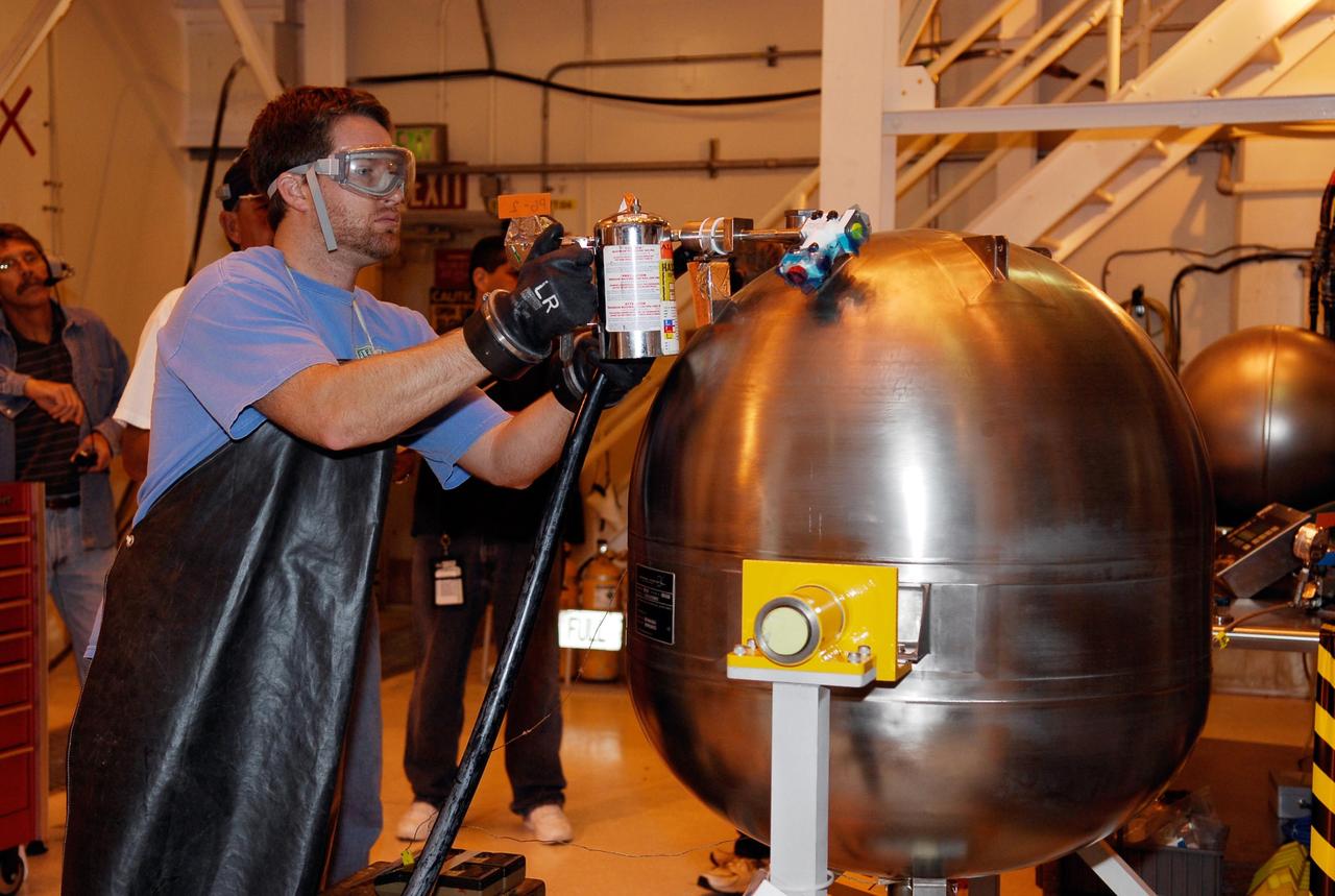 KENNEDY SPACE CENTER, FLA. -- In the hypergolic maintenance facility at NASA's Kennedy Space Center, a technician adjusts equipment during testing of the Ares I-X Roll Control System, or RoCS. The RoCS Servicing Simulation Test is to gather data that will be used to help certify the ground support equipment design and validate the servicing requirements and processes. The RoCS is part of the Interstage structure, the lowest axial segment of the Upper Stage Simulator. In an effort to reduce costs and meet the schedule, most of the ground support equipment that will be used for the RoCS servicing is of space shuttle heritage. This high-fidelity servicing simulation will provide confidence that servicing requirements can be met with the heritage system. At the same time, the test will gather process data that will be used to modify or refine the equipment and processes to be used for the actual flight element. Photo credit: NASA/Kim Shiflett