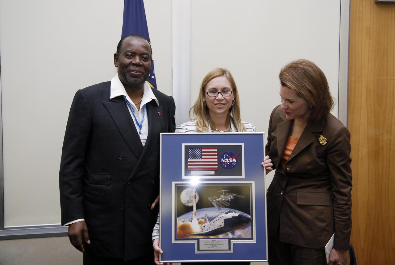 KENNEDY SPACE CENTER, FLA. --   His Excellency Jerome Mendouga (left), Ambassador of Cameroon to the United States, and The Honorable Nancy Brinker (right), U.S. Ambassador, accept a presentation from Janet Petro, Kennedy deputy director, on the occasion of The Chiefs of Diplomatic Missions visit to Kennedy. The visit, one of the largest tours undertaken by the diplomatic corps, is part of the State Department's new Experience America program. The international dignitaries were provided an overview of the United States' space exploration programs and NASA's international cooperation in pursuit of exploration and scientific discovery. They visited various locations at Kennedy, including the Space Station Processing Facility and Launch Pad 39A where space shuttle Atlantis is being prepared for its upcoming mission to the International Space Station. Photo credit: NASA/Kim Shiflett