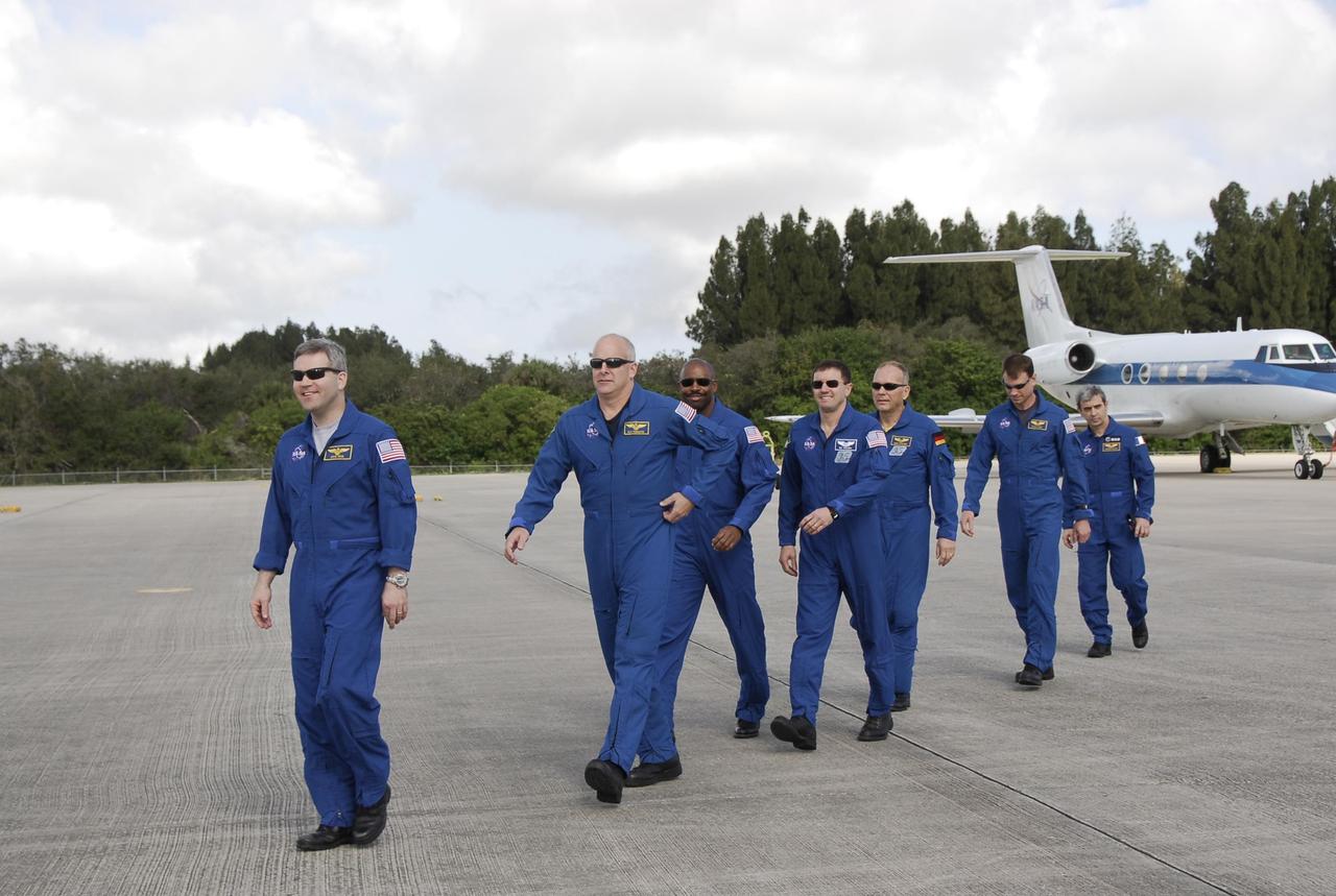 KENNEDY SPACE CENTER, FLA. -- After their arrival at NASA's Kennedy Space Center, the STS-122 crew heads for a microphone to greet the media waiting for them. From left are Commander Steve Frick, Pilot Alan Poindexter, and Mission Specialists Leland Melvin, Rex Walheim, Hans Schlegel, Stanley Love and Leopold Eyharts. Eyharts and Schlegel represent the European Space Agency. The crew's arrival signals the imminent launch of space shuttle Atlantis' STS-122 mission, at 2:45 p.m. Feb. 7. This will be the third launch attempt for the mission. Some of the tank's ECO sensors gave failed readings during propellant tanking for launch attempts on Dec. 6 and Dec. 9, subsequently scrubbing further attempts until the cause could be found and repairs made. Atlantis will carry the Columbus module, Europe's largest contribution to the construction of the International Space Station. It will support scientific and technological research in a microgravity environment. Columbus is a multifunctional, pressurized laboratory that will be permanently attached to the Harmony module of the space station to carry out experiments in materials science, fluid physics and biosciences, as well as to perform a number of technological applications. Photo credit: NASA/Kim Shiflett