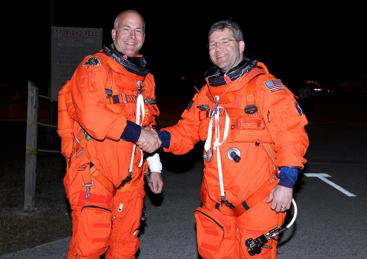 KENNEDY SPACE CENTER, FLA. -- STS-122 Pilot Alan Poindexter (left) and Commander Steve Frick  congratulate each other on successful completion of practice shuttle landings in the shuttle training aircraft. before the Feb. 7 launch of space shuttle Atlantis. The STA is a Grumman American Aviation-built Gulf Stream II jet that was modified to simulate an orbiter's cockpit, motion and visual cues, and handling qualities. In flight, the STA duplicates the orbiter's atmospheric descent trajectory from approximately 35,000 feet altitude to landing on a runway. Because the orbiter is unpowered during re-entry and landing, its high-speed glide must be perfectly executed the first time.  Photo credit: NASA/Kim Shiflett