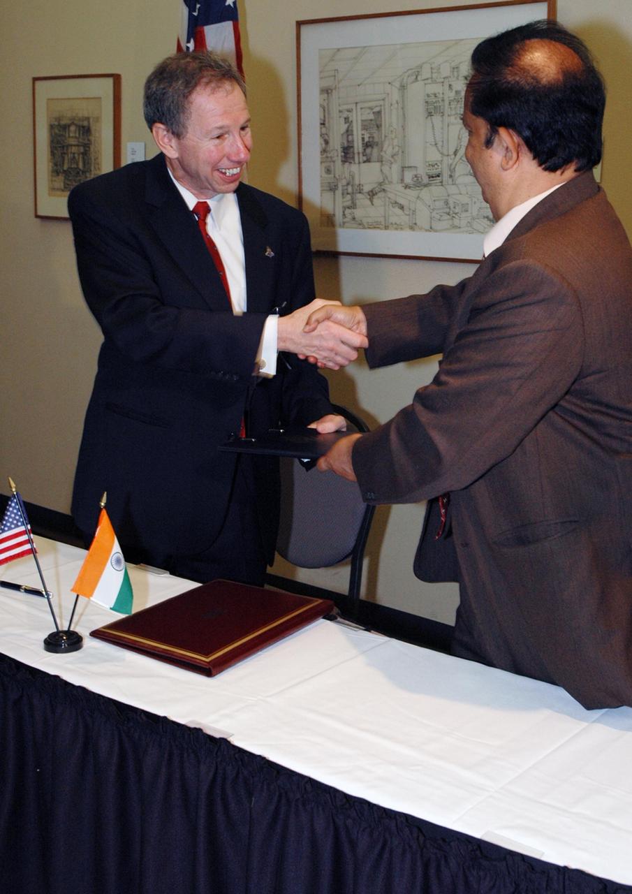 KENNEDY SPACE CENTER, FLA. -- At the NASA's Kennedy Space Center Visitor Complex, NASA Administrator Michael Griffin (left) and Indian Space Research Organization Chairman G. Madhavan Nair show their pleasure after signing a framework agreement establishing the terms for future cooperation between the two agencies in the exploration and use of outer space for peaceful purposes. According to the framework agreement, the two agencies will identify areas of mutual interest and seek to develop cooperative programs or projects in Earth and space science, exploration, human space flight and other activities. In addition to a long history of cooperation in Earth science, NASA and the Indian Space Research Organization also are cooperating on India's first, mission to the moon, Chandrayaan-1, which will be launched later this year. NASA is providing two of the 11 instruments on the spacecraft: the moon mineralogy mapper instrument and the miniature synthetic aperture radar instrument. Photo credit: NASA/Kim Shiflett