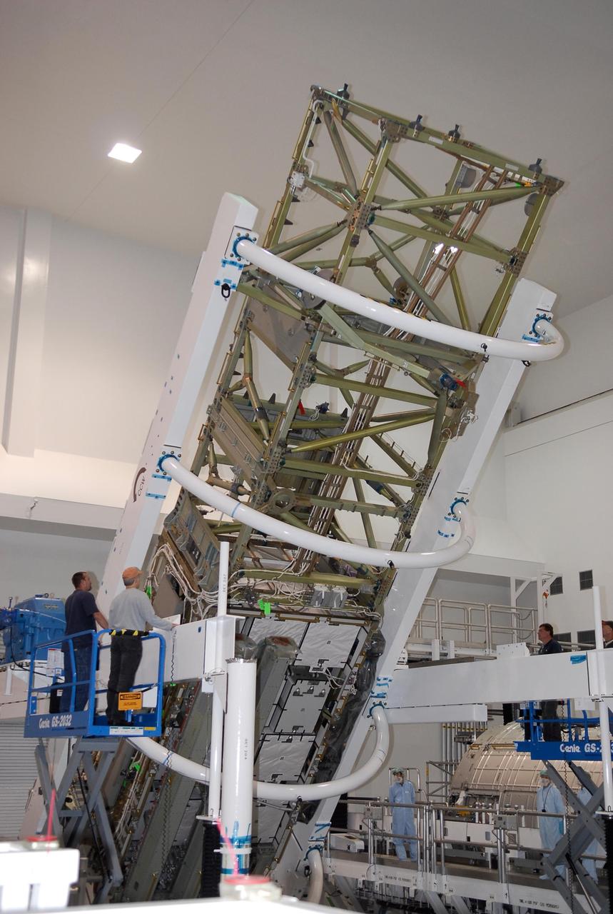 KENNEDY SPACE CENTER, FLA. -- In the Space Station Processing Facility at NASA's Kennedy Space Center, workers stand ready as the starboard integrated truss, known as S6, is rotated in order to remove and replace lower deck batteries. The final starboard truss in the assembly of the International Space Station, the S6 is scheduled to fly on the STS-119 space shuttle mission, whose launch date is not yet determined. Photo credit: NASA/Kim Shiflett