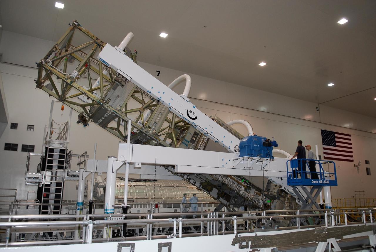 KENNEDY SPACE CENTER, FLA. -- In the Space Station Processing Facility at NASA's Kennedy Space Center, workers stand ready as the starboard integrated truss, known as S6, is three-fourths of the way through its rotation. The truss is being rotated in order to remove and replace lower deck batteries. The final starboard truss in the assembly of the International Space Station, the S6 is scheduled to fly on the STS-119 space shuttle mission, whose launch date is not yet determined. Photo credit: NASA/Kim Shiflett