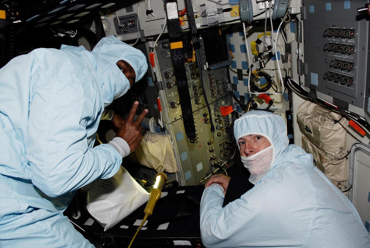 KENNEDY SPACE CENTER, FLA. --  On the flight deck of space shuttle Atlantis, STS-122 crew members inspect the cables for cameras used on their flight.  At left is Leland Melvin and at right is Stanley Love, both mission specialists.  The STS-122 mission to the International Space Station is scheduled to launch at 2:45 p.m. Feb. 7 with a crew of seven.  Atlantis will carry the Columbus Laboratory, Europe's largest contribution to the construction of the station.  Columbus will support scientific and technological research in a microgravity environment. Columbus is a multifunctional, pressurized laboratory that will be permanently attached to the Harmony module to carry out experiments in materials science, fluid physics and biosciences, as well as to perform a number of technological applications.    Photo credit: NASA/Kim Shiflett