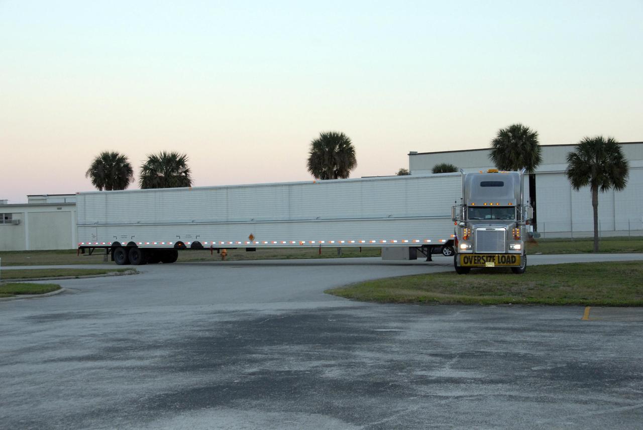 KENNEDY SPACE CENTER, FLA. --  The truck carrying the United Launch Alliance Delta II first stage arrives at Hangar M on Cape Canaveral Air Force Station in Florida.  The Delta rocket will be used to launch the Gamma-Ray Large Area Space Telescope, or GLAST, in May from Launch Pad 17-B on CCAFS.  The GLAST is a powerful space observatory that will explore the Universe's ultimate frontier, where nature harnesses forces and energies far beyond anything possible on Earth;  probe some of science's deepest questions, such as what our Universe is made of, and search for new laws of physics; explain how black holes accelerate jets of material to nearly light speed; and help crack the mystery of stupendously powerful explosions known as gamma-ray bursts.   Photo credit: NASA/George Shelton