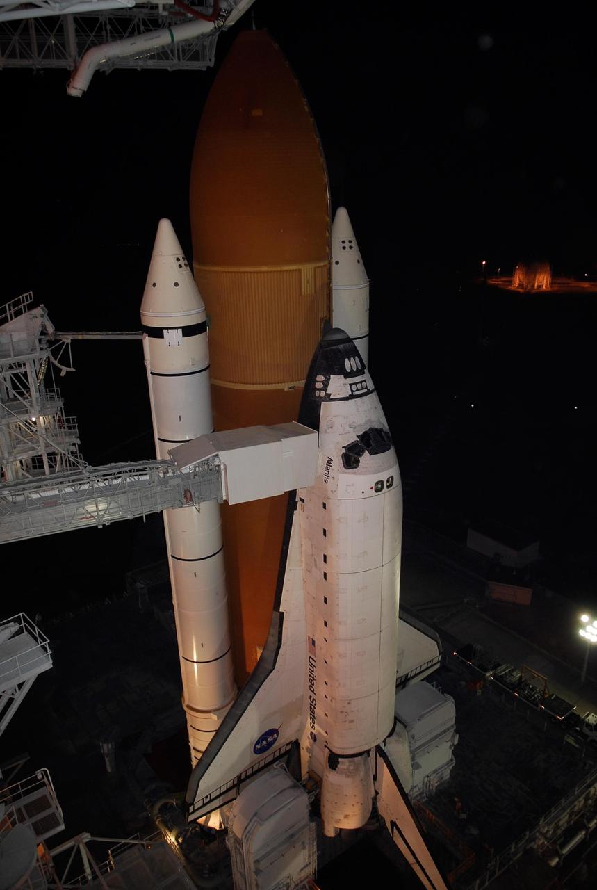 KENNEDY SPACE CENTER, FLA. -- On Launch Pad 39A at NASA's Kennedy Space Center, the orbiter access arm, which extends from the Fixed Service Structure, is positioned against space shuttle Atlantis following the rollback of the rotating service structure, or RSS.  Movement of the RSS began at 7:27 p.m. EST.    The RSS provides protected access to the orbiter for crew entry and servicing of payloads at the pad. Rollback of the pad's RSS is one of the milestones in preparation for the launch of mission STS-122, scheduled for 2:45 p.m. EST on Feb. 7.  This will be the third launch attempt for Atlantis since December 2007 to carry the Columbus Laboratory to the International Space Station.  Beneath the shuttle is the mobile launcher platform which supports the shuttle until liftoff.  Photo credit: NASA/Kim Shiflett