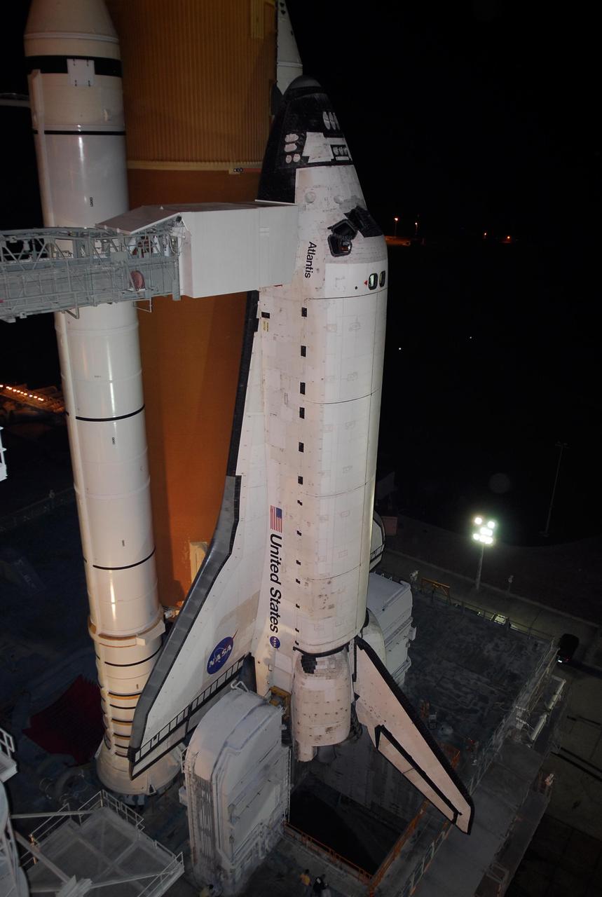 KENNEDY SPACE CENTER, FLA. -- On Launch Pad 39A at NASA's Kennedy Space Center, the orbiter access arm, which extends from the Fixed Service Structure, is positioned against space shuttle Atlantis following the rollback of the rotating service structure, or RSS.  Movement of the RSS began at 7:27 p.m. EST.    The RSS provides protected access to the orbiter for crew entry and servicing of payloads at the pad. Rollback of the pad's RSS is one of the milestones in preparation for the launch of mission STS-122, scheduled for 2:45 p.m. EST on Feb. 7.  This will be the third launch attempt for Atlantis since December 2007 to carry the Columbus Laboratory to the International Space Station.  Beneath the shuttle is the mobile launcher platform which supports the shuttle until liftoff.  Photo credit: NASA/Kim Shiflett