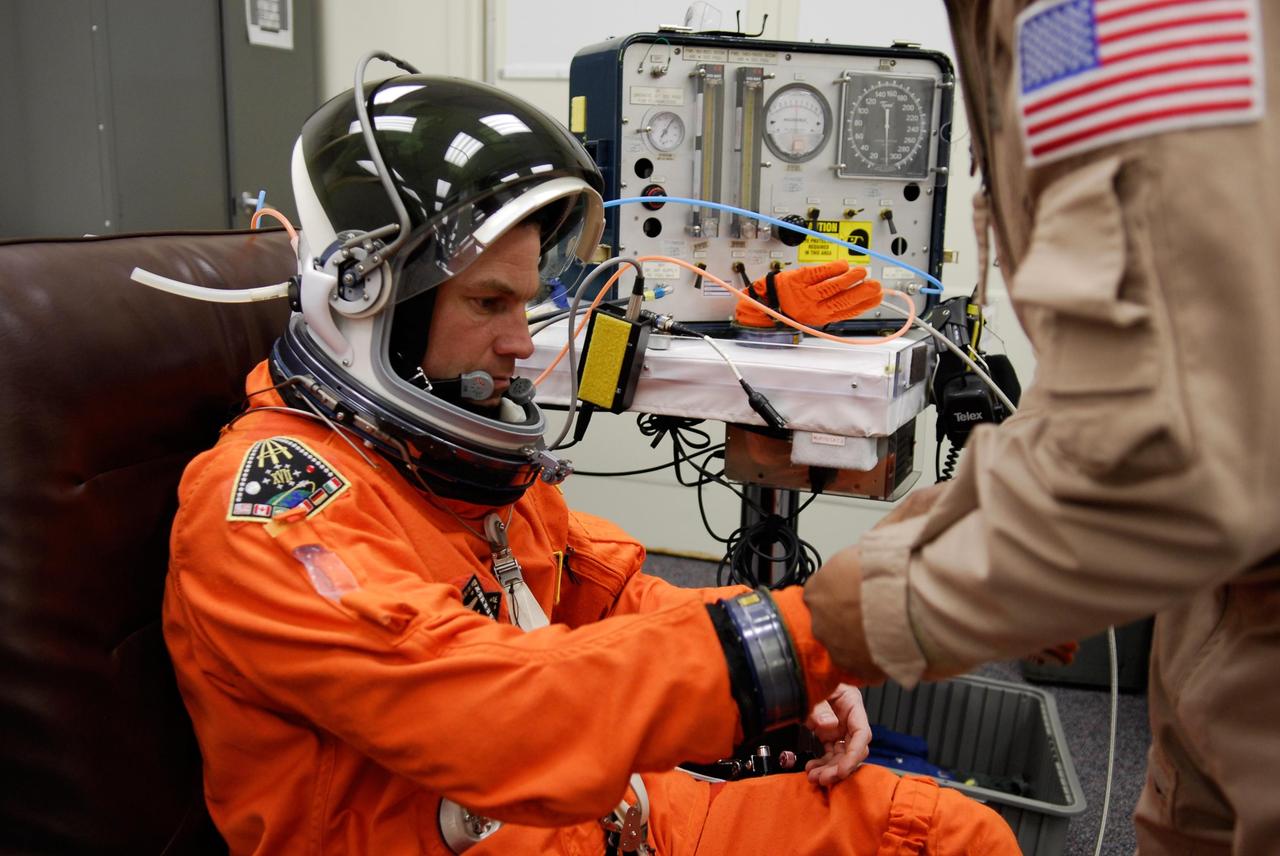 KENNEDY SPACE CENTER, FLA. --Mission Specialist Stanley Love gets help with his gloves to complete his suitup for launch of space shuttle Atlantis on the STS-122 mission. The launch, scheduled for 2:45 p.m. EST, will be the third attempt for Atlantis since December 2007 to carry the European Space Agency's Columbus laboratory to the International Space Station. During the 11-day mission, the crew's prime objective is to attach the laboratory to the Harmony module, adding to the station's size and capabilities. Photo credit: NASA/Kim Shiflett