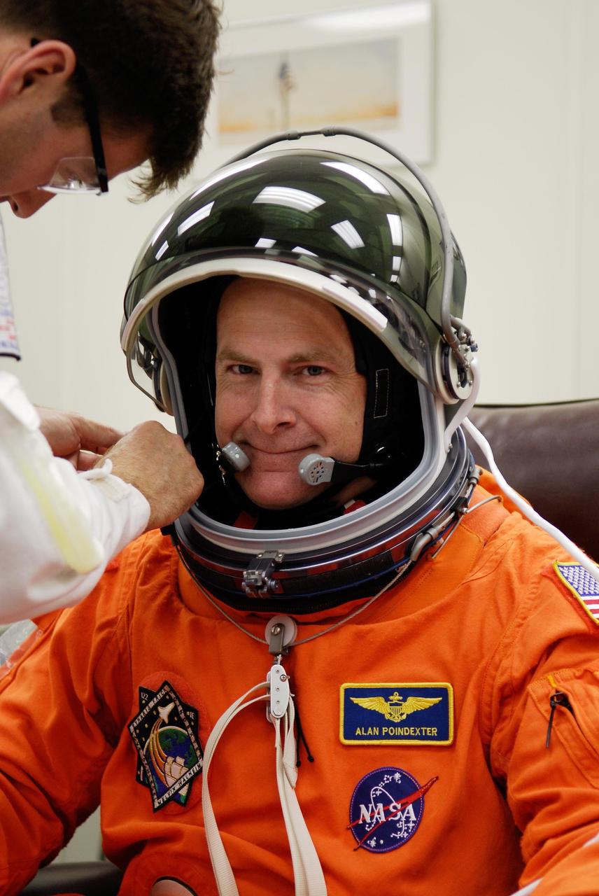 KENNEDY SPACE CENTER, FLA. -- Pilot Alan Poindexter is helped with his helmet while donning his launch and entry suit for launch of space shuttle Atlantis on the STS-122 mission. The launch, scheduled for 2:45 p.m. EST, will be the third attempt for Atlantis since December 2007 to carry the European Space Agency's Columbus laboratory to the International Space Station. During the 11-day mission, the crew's prime objective is to attach the laboratory to the Harmony module, adding to the station's size and capabilities. Photo credit: NASA/Kim Shiflett