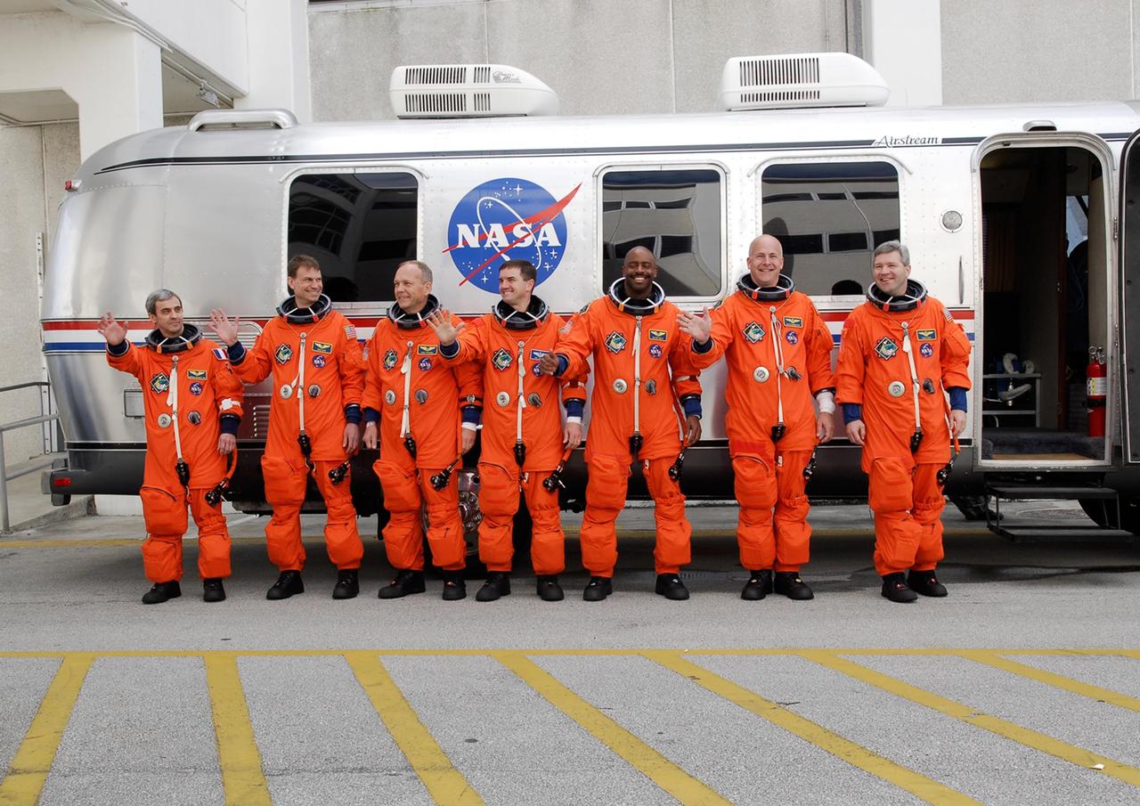 KENNEDY SPACE CENTER, FLA. -- The STS-122 crew pauses alongside the Astrovan to wave farewell to onlookers before heading for Launch Pad 39A for the launch of space shuttle Atlantis on the STS-122 mission. From left are Mission Specialists Leopold Eyharts, Stanley Love, Hans Schlegel, Rex Walheim and Leland Melvin, Pilot Alan Poindexter and Commander Steve Frick. The launch will be the third attempt for Atlantis since December 2007 to carry the European Space Agency's Columbus laboratory to the International Space Station. During the 11-day mission, the crew's prime objective is to attach the laboratory to the Harmony module, adding to the station's size and capabilities. Photo credit: NASA/Kim Shiflett