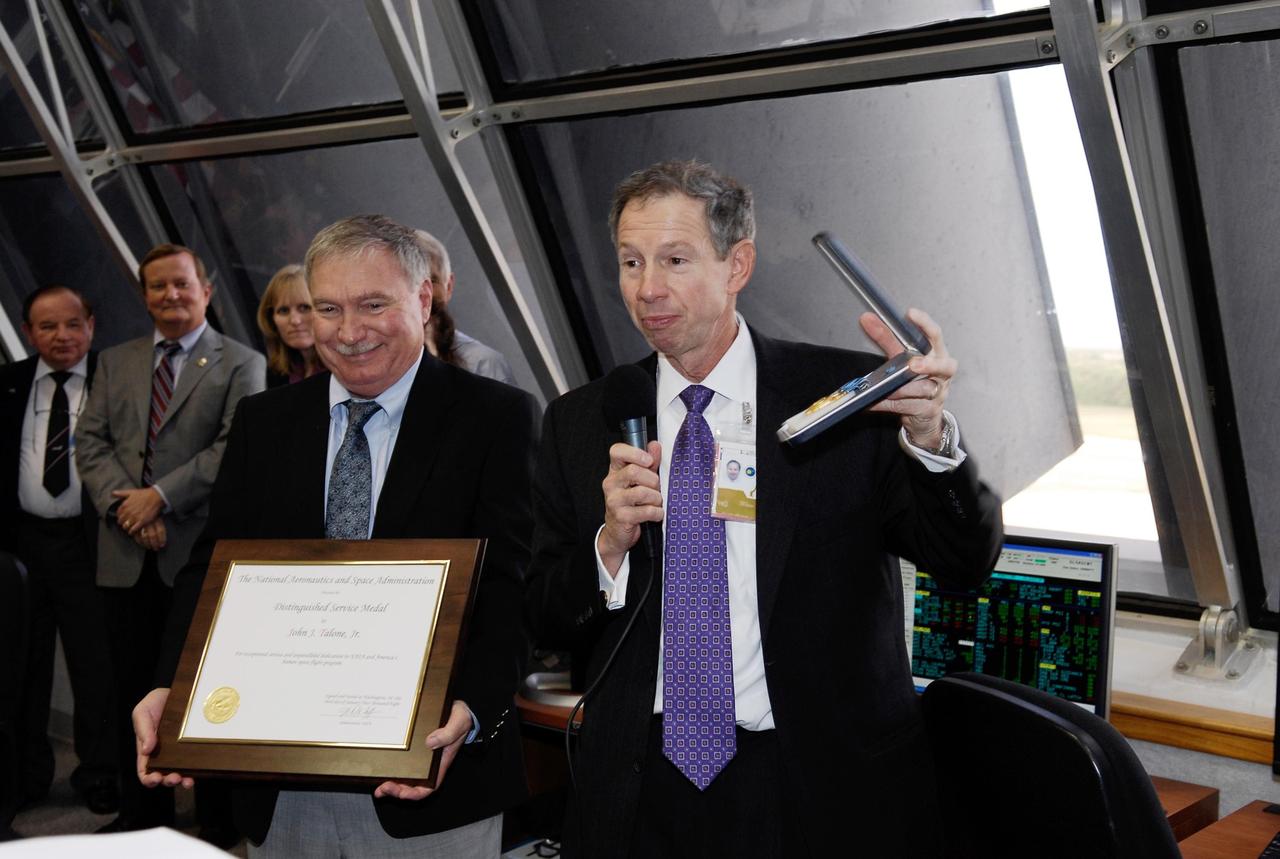 KENNEDY SPACE CENTER, FLA. -- Inside the Launch Control Center Firing Room at NASA's Kennedy Space Center, NASA Administrator Michael Griffin (right) presents a special distinguished service medal to John J. "Tip" Talone Jr. for exceptional service and unparalleled dedication to NASA and America's human space flight program.  Currently, John J. "Tip" Talone Jr. serves as the director of the Kennedy Space Center Constellation Project Office of the NASA Constellation Program. From 1996 to 2005, he was director of the International Space Station Hardware Integration Office, which became the ISS/Payloads Processing Directorate in May 2000.  The presentation followed the launch of space shuttle Atlantis on mission STS-122, which lifted off at 2:45 p.m. EST. Photo credit: NASA/Kim Shiflett