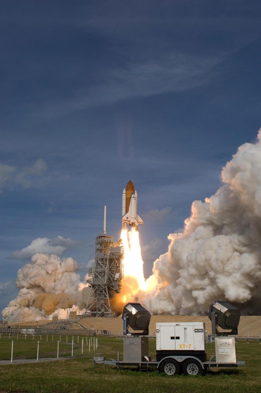 KENNEDY SPACE CENTER, FLA. --  Space shuttle Atlantis majestically leaps into the sky, leaving behind clouds of smoke and steam, as it heads for the International Space Station on mission STS-122.  In the foreground ar xenon lights used to light the shuttle and launch pad at night.  Liftoff of the shuttle was on time at 2:45 p.m. EST. The launch is the third attempt for Atlantis since December 2007 to carry the European Space Agency's Columbus laboratory to the International Space Station.  During the 11-day mission, the crew's prime objective is to attach the laboratory to the Harmony module, adding to the station's size and capabilities.    Photo credit: NASA/Sandra Joseph, Tony Gray, Robert Murray