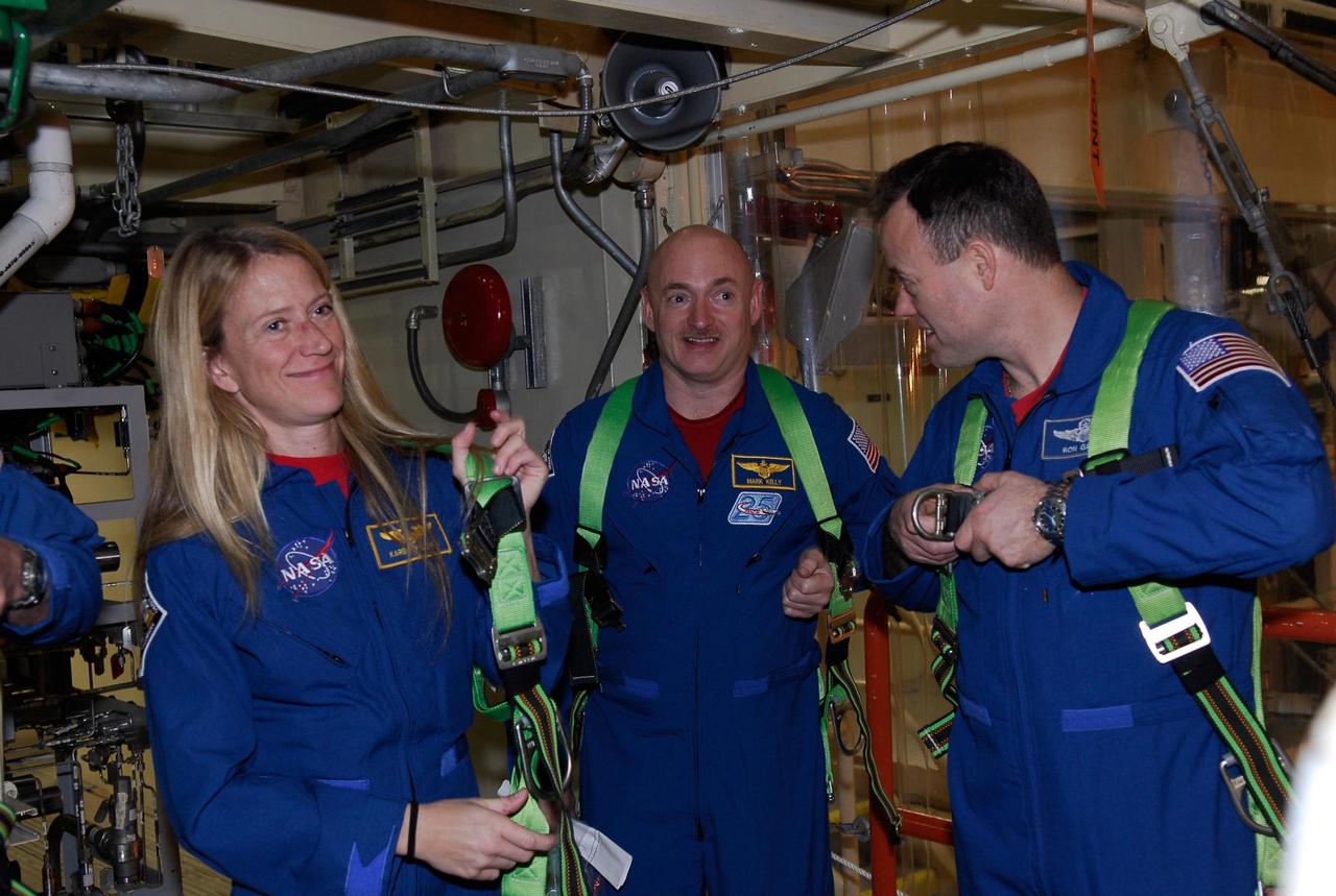 KENNEDY SPACE CENTER, FLA. -- Members of space shuttle Discovery's STS-124 crew put on safety harnesses in the Orbiter Processing Facility bay 3 at NASA's Kennedy Space Center during a crew equipment interface test. From left are Mission Specialist Karen Nyberg, Pilot Mark Kelly and Mission Specialist Ronald Garan. On the mission, Discovery will transport the Kibo Japanese Experiment Module - Pressurized Module (JEM-PM) and the Japanese Remote Manipulator System (JEM-RMS) to the International Space Station to complete the Kibo laboratory. The launch of Discovery is targeted for April 24. Photo credit: NASA/Kim Shiflett