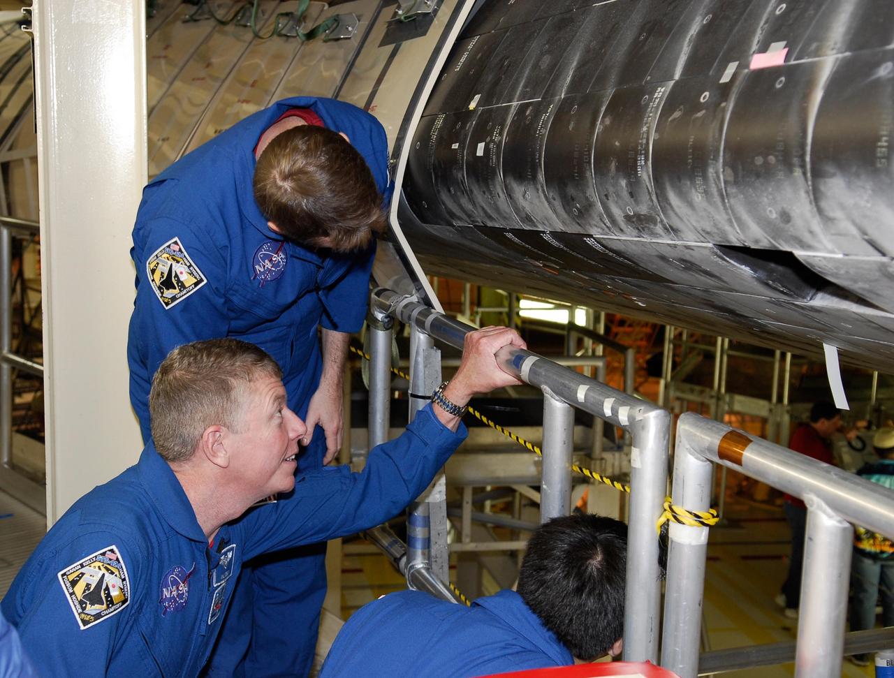 KENNEDY SPACE CENTER, FLA. -- In the Orbiter Processing Facility bay 3 at NASA's Kennedy Space Center, members of the STS-124 crew inspect space shuttle Discovery during a crew equipment interface test. Seen, top to bottom are Pilot Kenneth Ham and Mission Specialists Michael Fossum and Akihiko Hoshide, who represents the Japan Aerospace Exploration Agency, called JAXA. On the mission, Discovery will transport the Kibo Japanese Experiment Module - Pressurized Module (JEM-PM) and the Japanese Remote Manipulator System (JEM-RMS) to the International Space Station to complete the Kibo laboratory. The launch of Discovery is targeted for April 24. Photo credit: NASA/Kim Shiflett