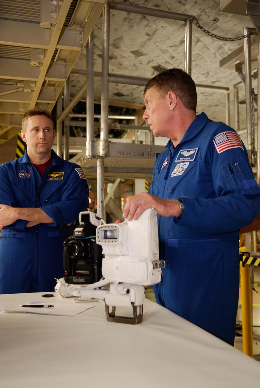 KENNEDY SPACE CENTER, FLA. -- During a crew equipment interface test in the Orbiter Processing Facility bay 3, space shuttle Discovery's STS-124 Pilot Kenneth Ham (left) and Mission Specialist Michael Fossum look at cameras that will be used on the mission. Discovery will transport the Kibo Japanese Experiment Module - Pressurized Module (JEM-PM) and the Japanese Remote Manipulator System (JEM-RMS) to the International Space Station to complete the Kibo laboratory. The launch of Discovery is targeted for April 24. Photo credit: NASA/Kim Shiflett